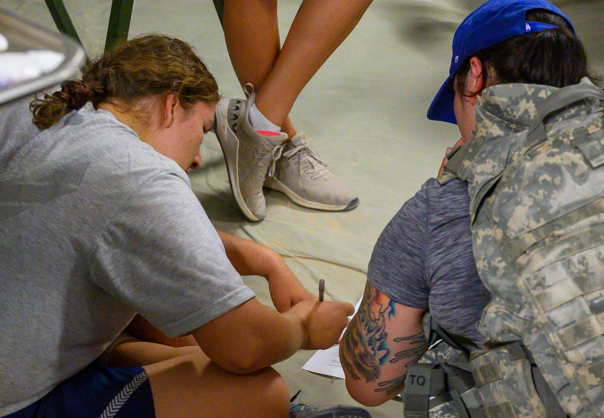 U.S. Air Force Staff Sgt. Susanna Schriever, 378th Expeditionary Medical Squadron medic, and U.S. Air Force Staff Sgt. Kelly Dzitko, 378th Expeditionary Medical Squadron respiratory therapist, complete the written portion of the first best medic competition at Prince Sultan Air Base, June 21, 2021.The competition was a culmination of the past 11 weeks of combat medicine training, testing their ability to provide care in unexpected situations. (U.S. Air Force photo by Senior Airman Samuel Earick)