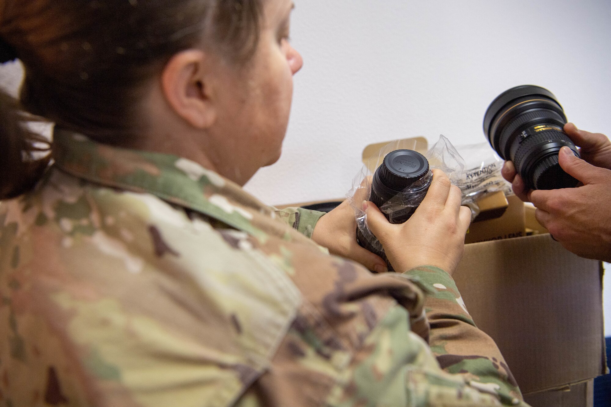 Airman holds camera lens