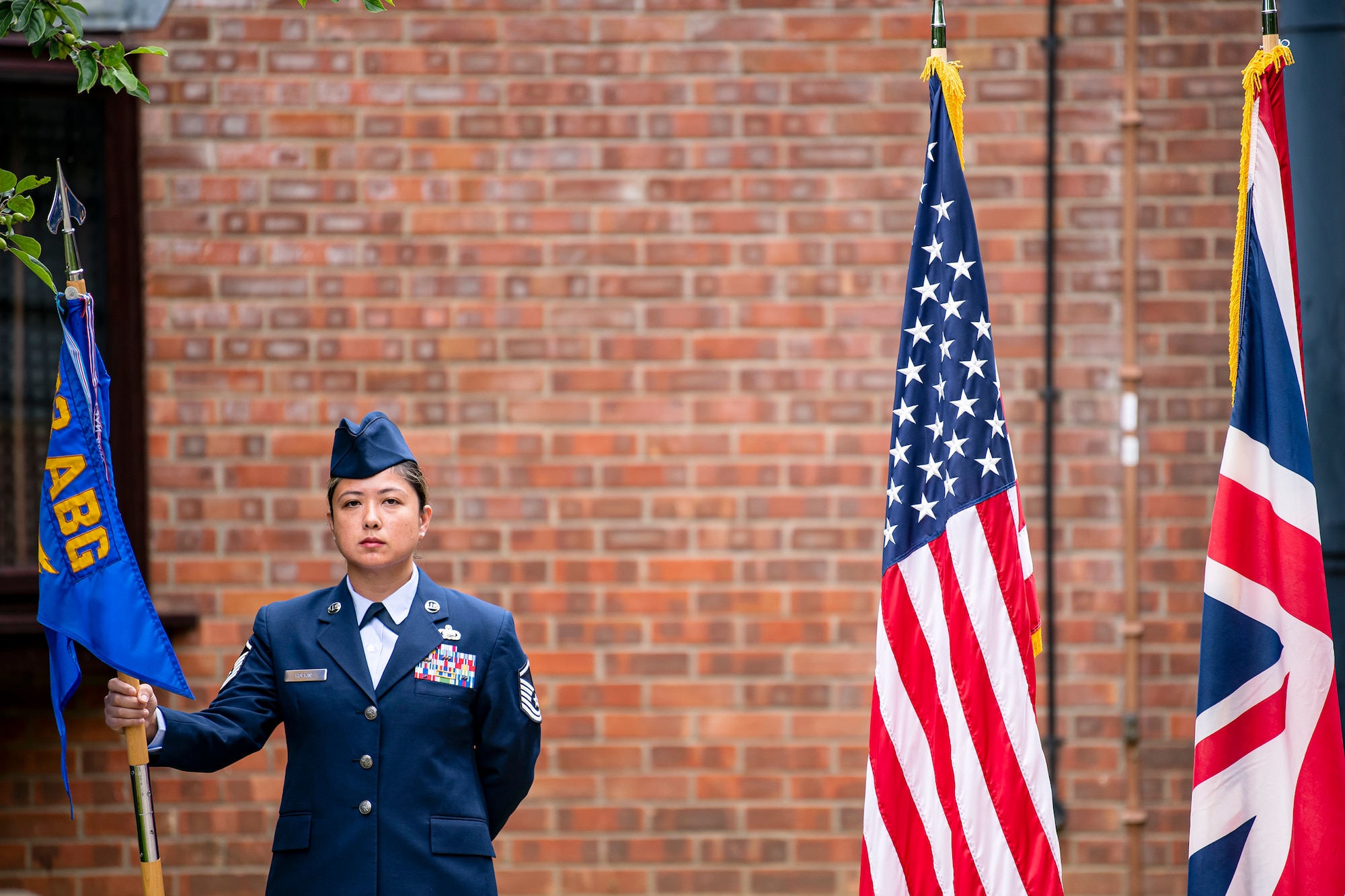U.S. Air Force Master Sgt. Mereille Hopkins, 423rd Force Support Squadron superintendent, holds the guidon during a change of command ceremony at RAF Alconbury, England, July 8, 2021. The ceremony is a military tradition that represents a formal transfer of a unit’s authority and responsibility from one commander to another. (U.S. Air Force photo by Senior Airman Eugene Oliver)