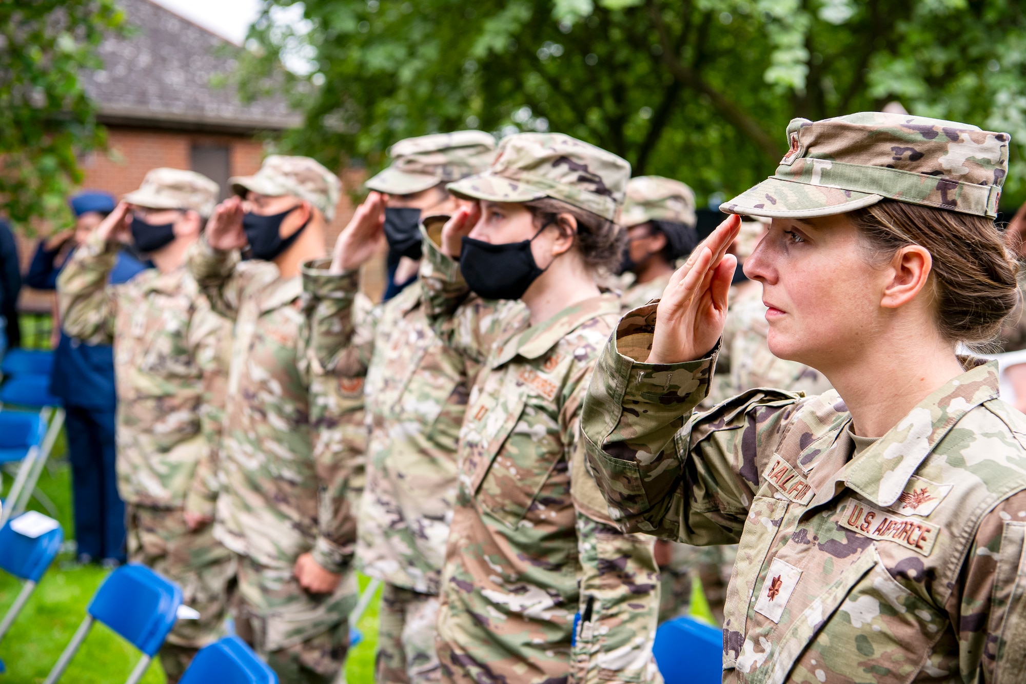 Airmen from the 501st Combat Support Wing, salute during a change of command ceremony at RAF Alconbury, England, July 8, 2021. The ceremony is a military tradition that represents a formal transfer of a unit’s authority and responsibility from one commander to another. (U.S. Air Force photo by Senior Airman Eugene Oliver)