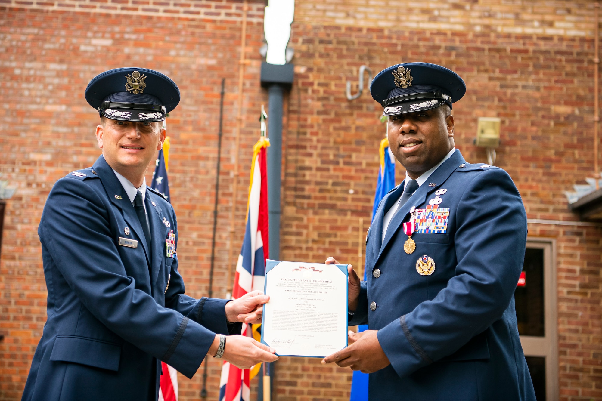 U.S. Air Force Col. Richard Martin, left, 423rd Air Base Group commander, presents a Meritorious Service Medal to Lt. Col. Jarvora Duncan, 423rd Force Support Squadron outgoing commander, during a change of command ceremony at RAF Alconbury, England, July 8, 2021. After relinquishing command of the 423rd FSS, Duncan will continue his career at MacDill Air Force Base, Florida. (U.S. Air Force photo by Senior Airman Eugene Oliver)