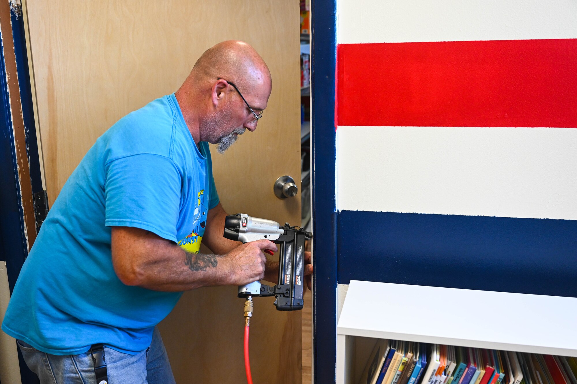 Darrell Lane, 733rd Mission Support Group, locksmith installs a door stop at the Fort Eustis USO at Joint Base Langley-Eustis, Virginia. June 28, 2021. The door upgrade is part of a series of small repairs and upgrades to improve the quality of the USO for all to enjoy. (U.S. Air Force photo by Senior Airman John Foister)