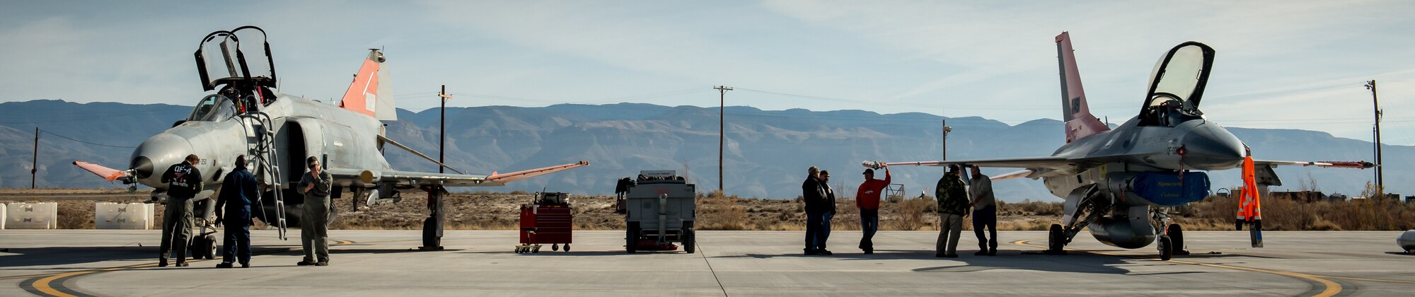 Ground crew of the 82nd Aerial Target Squadron Detachment 1 perform maintenance on a QF-4 Phantom, left, and its replacement, the QF-16, at Holloman AFB, N.M., Dec. 20, 2016. The final variant of the Phantom II, the primary multi-role aircraft in the USAF throughout the 1960s and 1970s, was the QF-4 unmanned aerial target flown by the 82nd at Holloman AFB. Pilots of the 82nd flew the F-4 for the last time prior to a retirement ceremony for the storied aircraft on Dec. 21, 2016. (U.S. Air Force photo by J.M. Eddins Jr.)