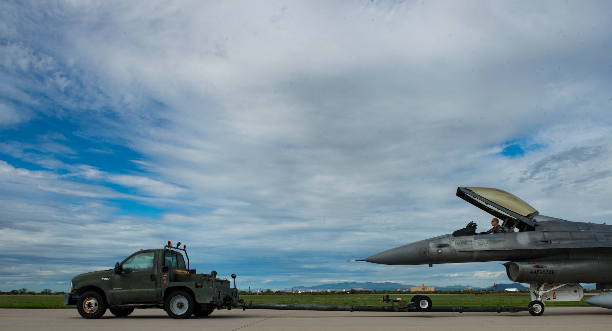 An F-16 Fighting Falcon is towed to the runway before takeoff, Aug 1, 2017 at Davis-Monthan Air Force Base, Ariz. The F-16 was pulled out of storage at the 309th Aerospace Maintenance and Regeneration Group and refurbished to fight status before being transported to Cecil Field, Jacksonville, Fl. where it will be converted into a QF-16 unmanned aerial target. (U.S. Air Force photo by Tech. Sgt. Perry Aston)