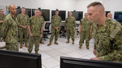 PENSACOLA, Fla. (June 24, 2021) Rear Adm. James Butler, commander, Naval Information Force Reserve (CNIFR) along with CNIFR’s Command Master Chief Kristie Barbier, participate in a Multipurpose Reconfigurable Training System 3D® (MRTS 3D®) technology training device demonstration and discussion with staff at the Center for Information Warfare Training and Information Warfare Training Command (IWTC) Corry Station. The two visited for a familiarization brief and tour of CIWT and IWTC Corry Station to review information warfare training initiatives and discuss current and future training for the Navy’s Reserve IW force (U.S. Navy photo by Glenn Sircy)