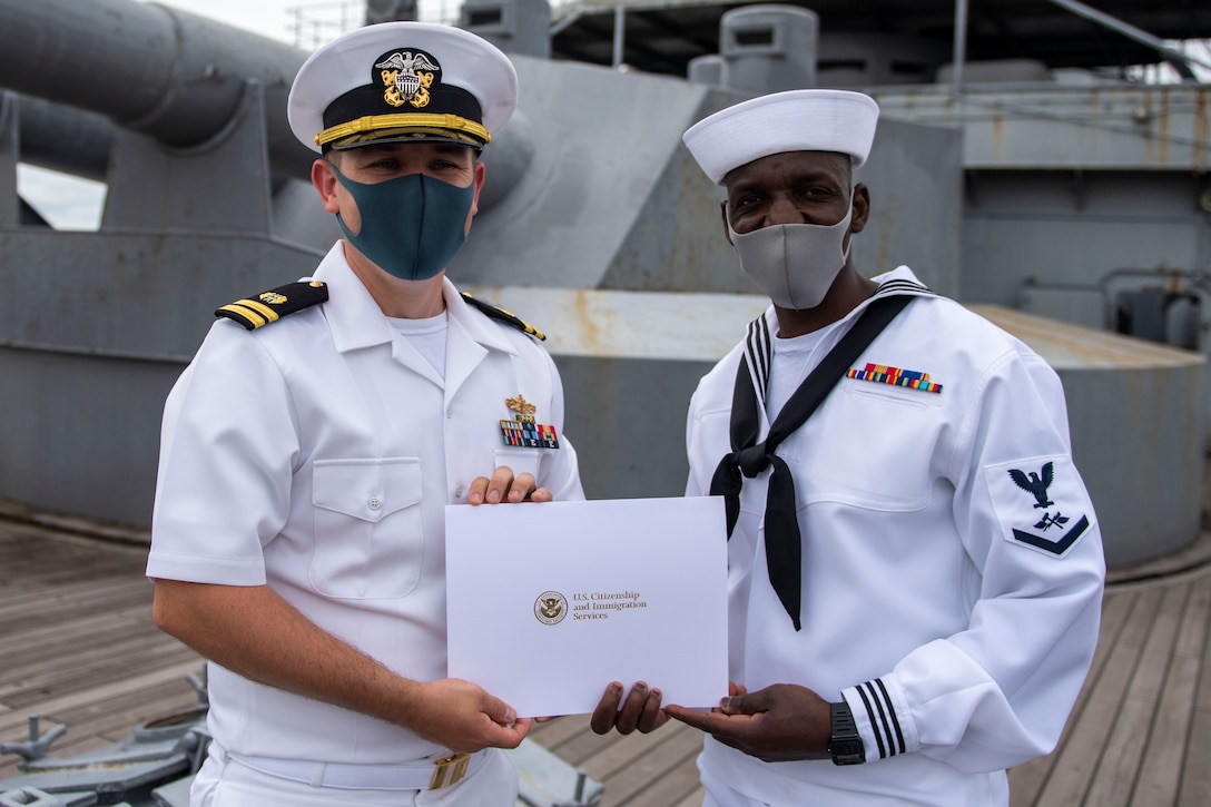 Two male sailors display a certificate.