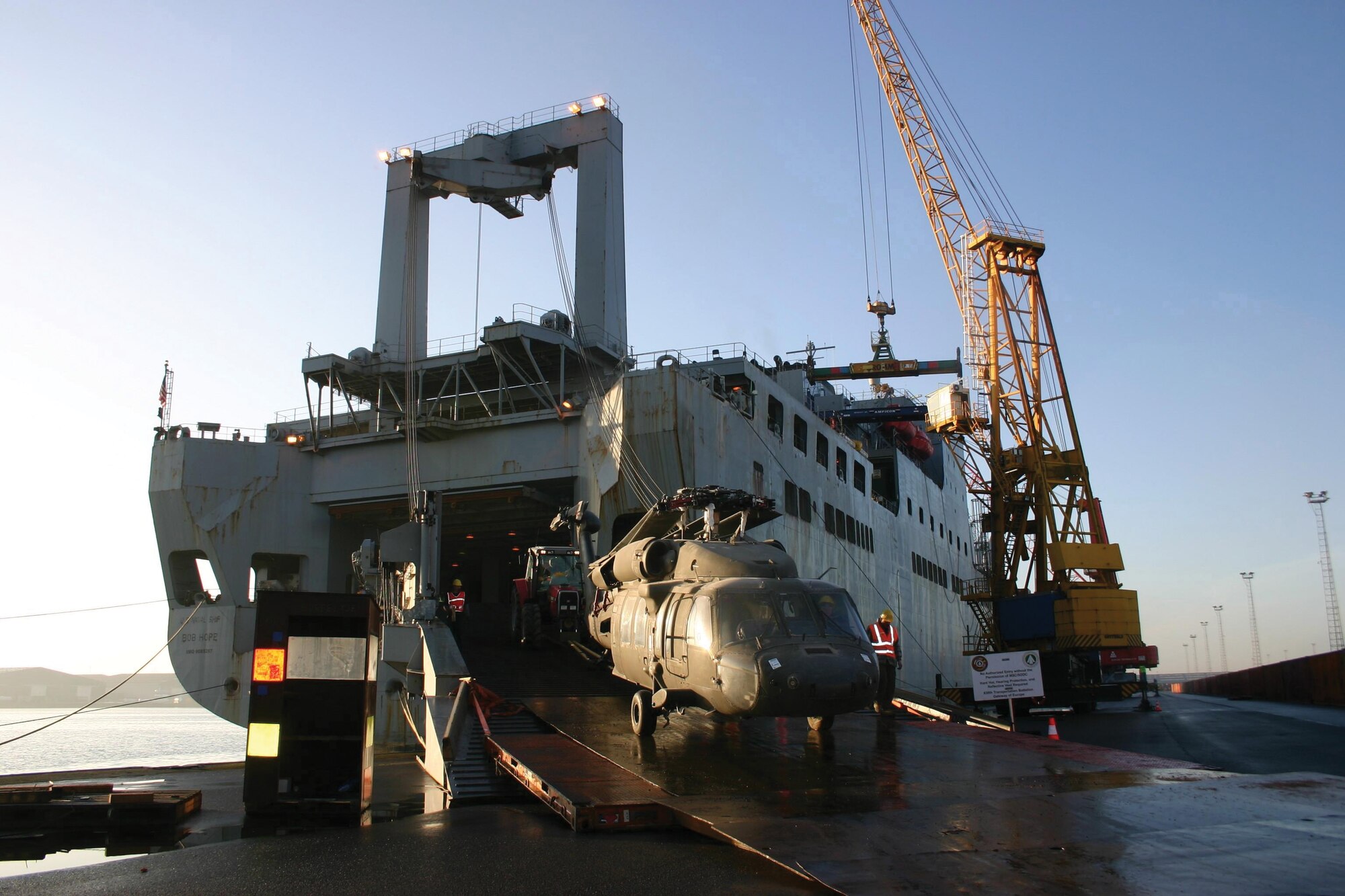 A helicopter is loaded onto USNS Bob Hope in Antwerp, Belgium. The USNS Bob Hope is crewed by civilian mariners under the United States Navy's Military Sealift Command, is used to preposition tanks, trucks and other supplies needed to support an Army heavy brigade. (U.S. Navy photo)