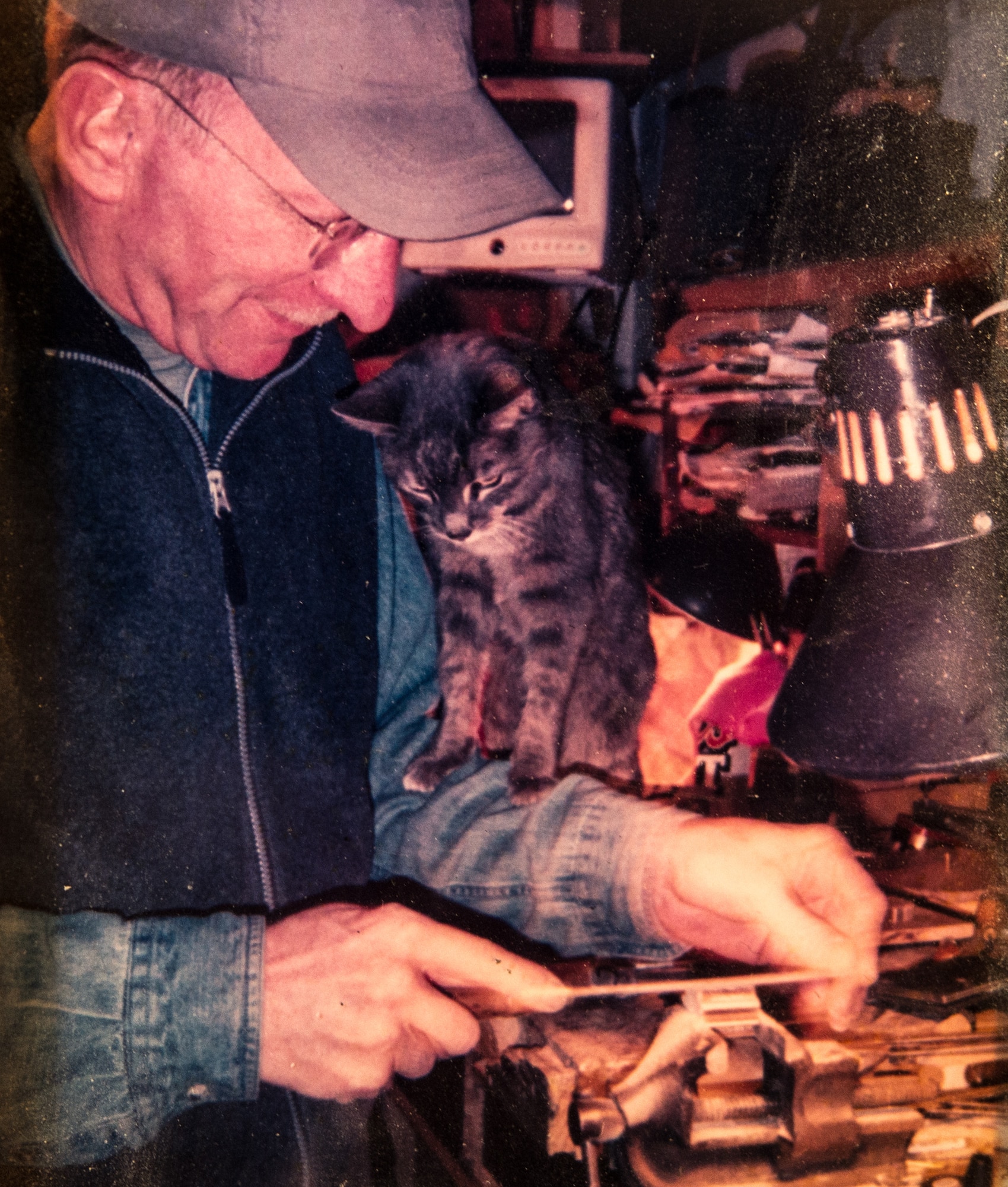Retired U.S. Air Force Master Sgt. Daniel Holmes, shown filing a piece of wood while one of his beloved cats watches him in a photo at his home in Lowell, Mass., Jun. 1, 2018. Holmes teaches Airmen various electronic and mechanical skills that they do not learn in tech school in order for them to maintain 1960's era technology used  at the Sagamore Hill Solar Observatory of the 2nd Weather Squadron, Det. 2, in Hamilton, Mass. (U.S. Air Force photo by J.M. Eddins Jr.)