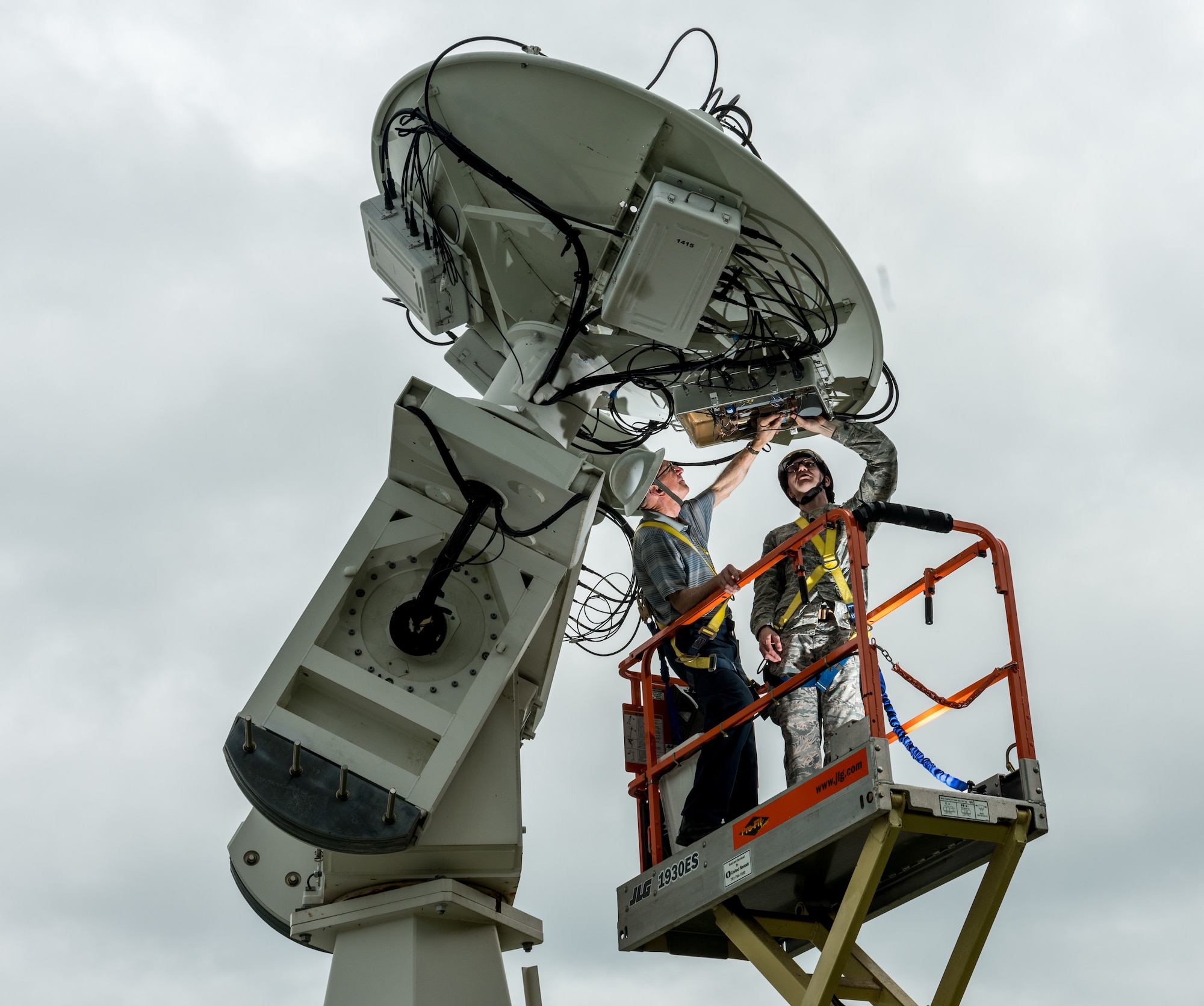Retired U.S. Air Force Master Sgt. Daniel Holmes, right, and Tech. Sgt. Kyle Duley, maintenance NCIOC, perform maintenance on a radio telescope dish at the Sagamore Hill Solar Observatory of the 2nd Weather Squadron, Det. 2, in Hamilton, Mass., Jun. 1, 2018. The 2nd WS, headquartered at Offutt Air Force Base, Neb., operates four solar observatories around the globe which enable constant monitoring of the sun for solar phenomenon which may interfere with electronics and communications used by the Department of Defense. (U.S. Air Force photo by J.M. Eddins Jr.)