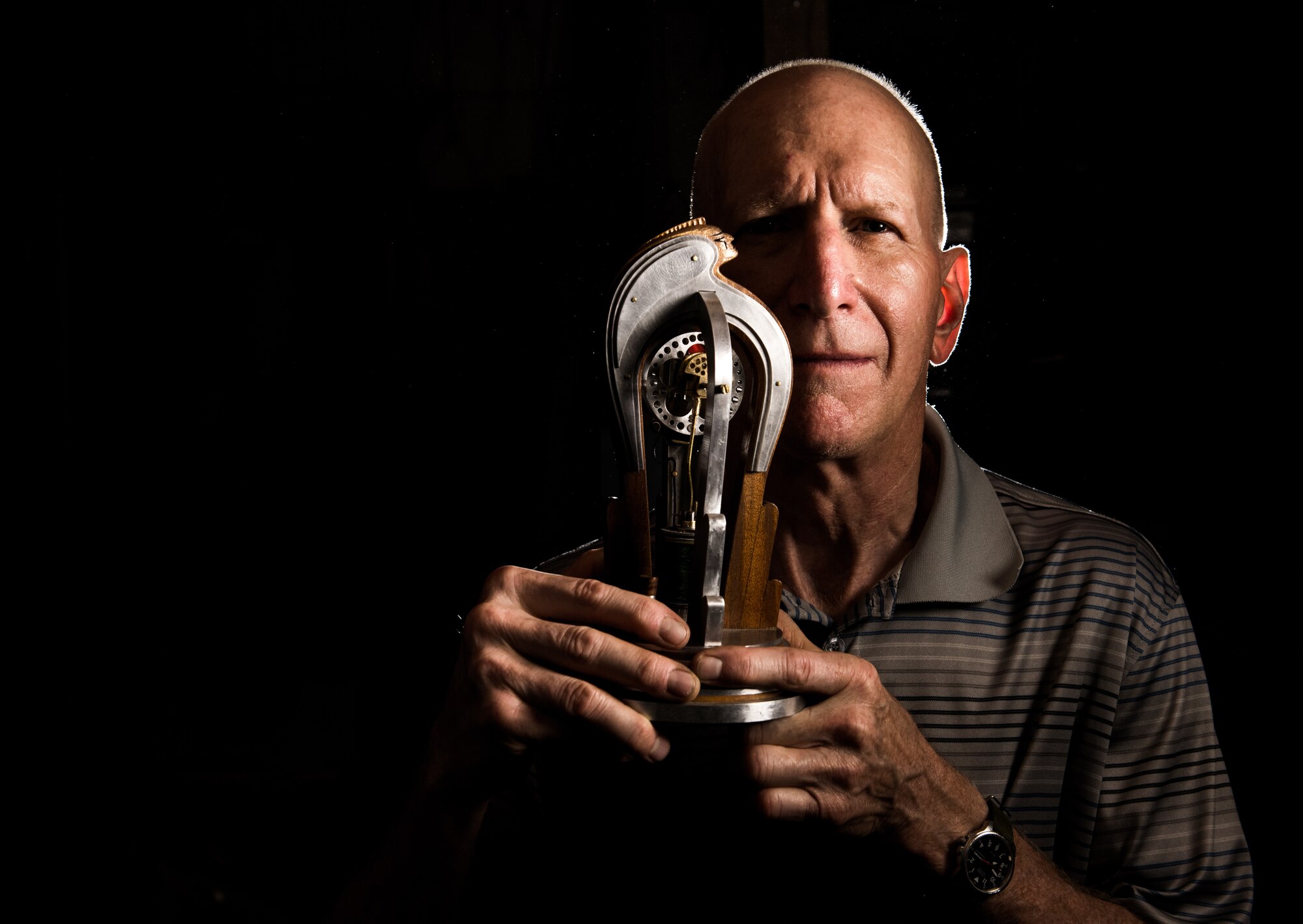 Retired U.S. Air Force Master Sgt. Daniel Holmes photographed at his home in Lowell, Mass. holding one of his handmade kinetic sculptures, Jun. 1, 2018. Holmes teaches Airmen various electronic and mechanical skills not taught during their technical training, often utilizing kinetic sculptures he builds by hand. The concepts enable Airmen to maintain 1960's era technology used  at the Sagamore Hill Solar Observatory of the 2nd Weather Squadron, Det. 2, in Hamilton, Mass. (U.S. Air Force photo by J.M. Eddins Jr.)