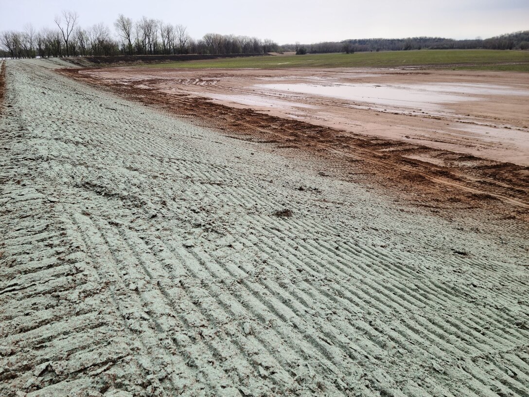 a levee embankment with tire tracks