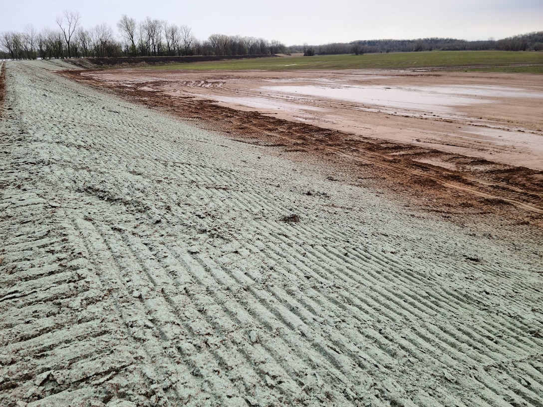 a levee embankment with tire tracks