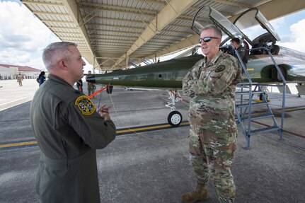 U.S. Air Force Gen. John E. Hyten speaks to Lt. Col. William Johnson in front of aircraft at Joint Base San Antonio-Randolph.