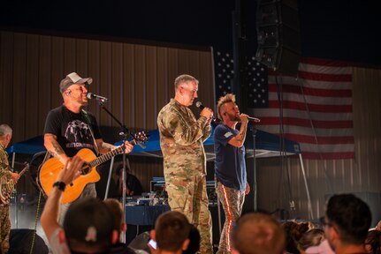 U.S. Air Force Gen. John E. Hyten performs on stage with the band LOCASH during the USO Summer Tour at Joint Base San Antonio-Lackland.