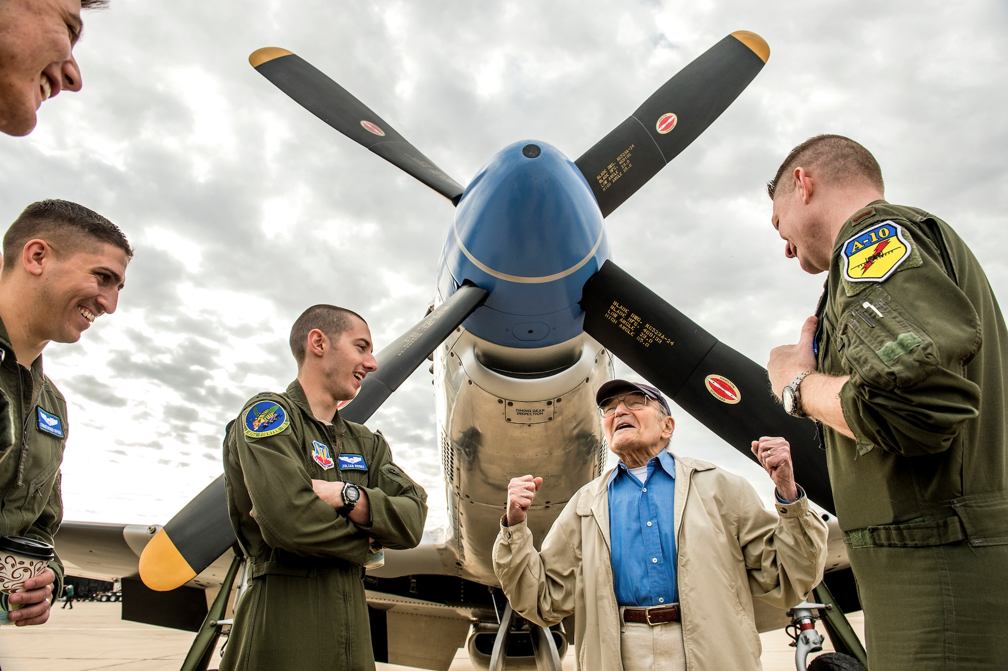 Student Pilots with the 47th Fighter Squadron, 1st Lt. Stephen Crump, top left, 1st Lt. Christopher Bryan, 1st Lt. Julian Rooks and 2nd Lt. Tanner Riddles, far right, listen to Bill Lyons, 94, tell a story about his days flying the P-51 Mustang, behind him,  over Europe during WWII  on the flight line at the Heritage Flight Training Course at Davis-Monthan AFB, Tucson, Ariz., Mar 6, 2016. (U.S. Air Force photo by J.M. Eddins Jr.)