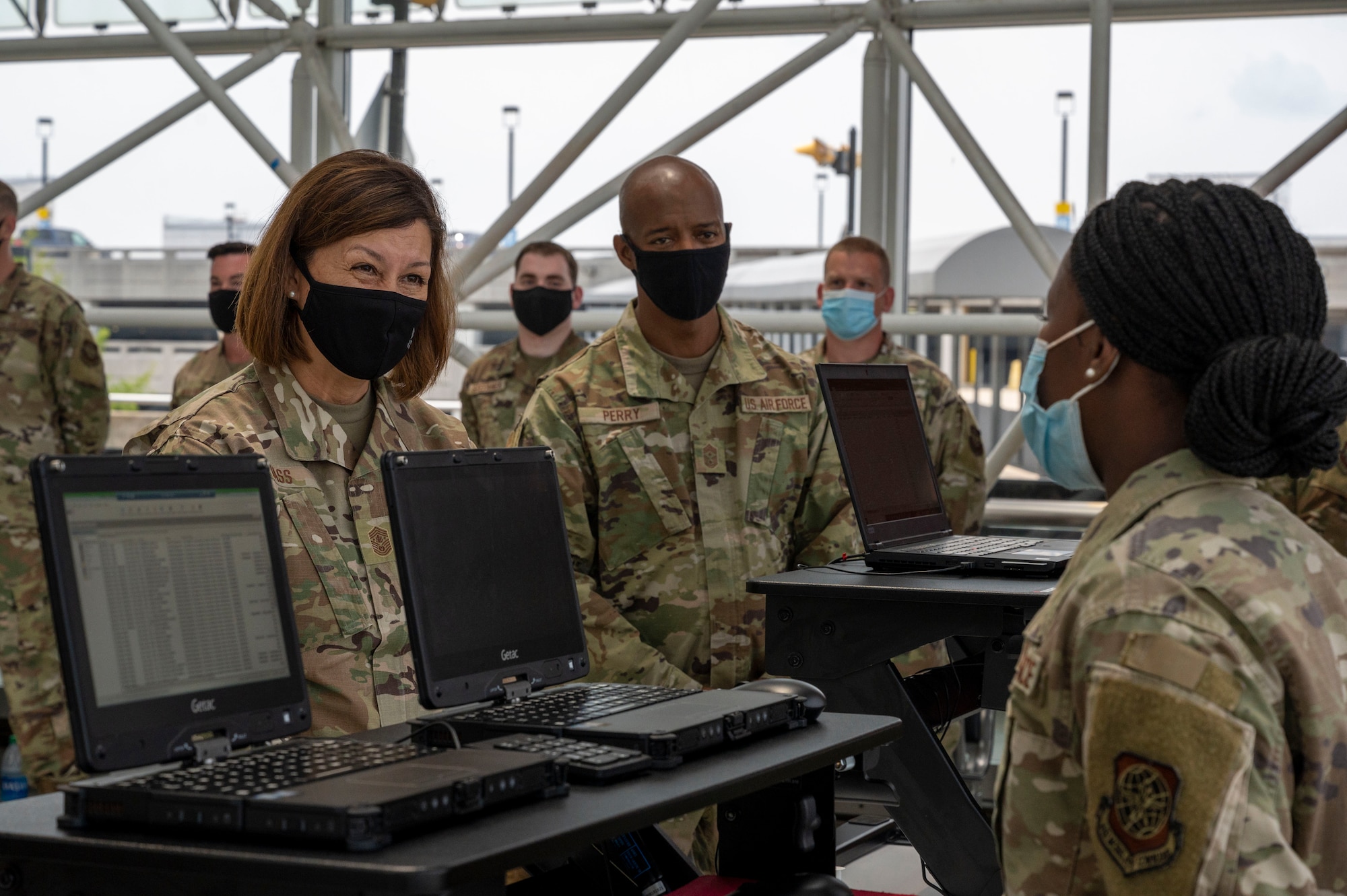 Chief Master Sgt. of the Air Force JoAnne S. Bass and Chief Master Sgt. Nathaniel Perry, Air Force First Sergeant Special Duty Manager, speak with Senior Airman Annette Kamau, 87th Health Care Operations Squadron medical technician, at the Patriot Express COVID-19 testing facility in the Baltimore/Washington International Thurgood Marshall Airport in Baltimore, July 8, 2021. Since November 2020, the operation ensured U.S. Transportation Command’s fulfillment of national security requirements while providing for the health and safety of service members and their families. Due to the increased availability in COVID-19 testing centers and vaccines, testing at the BWI facility is scheduled to discontinue July 15, 2021. (U.S. Air Force photo by Airman 1st Class Cydney Lee)
