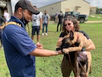 Student plays with puppy.