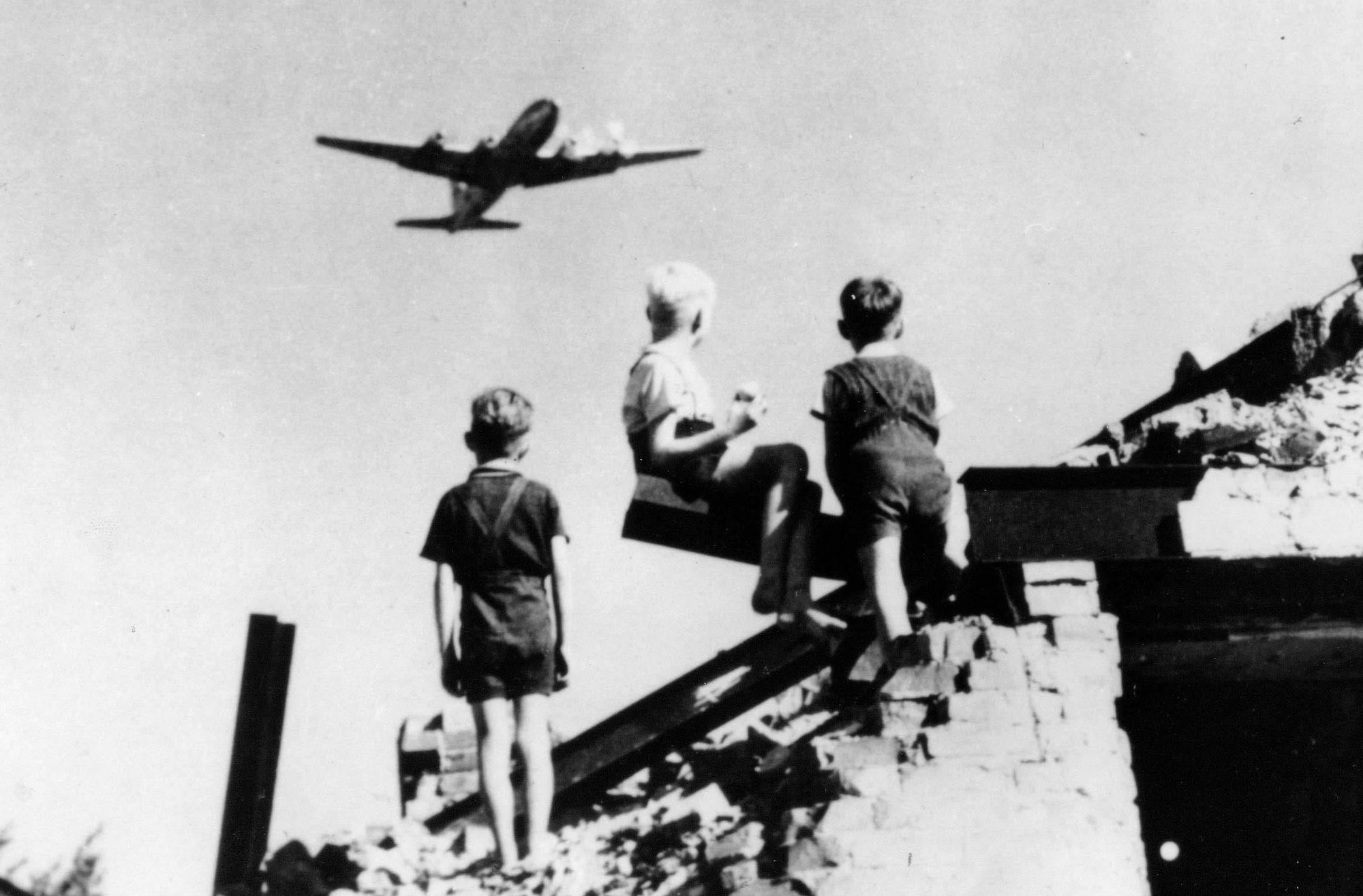 Children in West Berlin watch U.S. Air Force transport planes land at Templehof Airport during the Berlin Airlift in 1948. During the height of the operation, an aircraft landed every thirty seconds in West Berlin. The USAF delivered 1,783,573 tons and the RAF 541,937, on a total of 278,228 flights from June, 1948 to May, 1949. (U.S. Air Force photo)