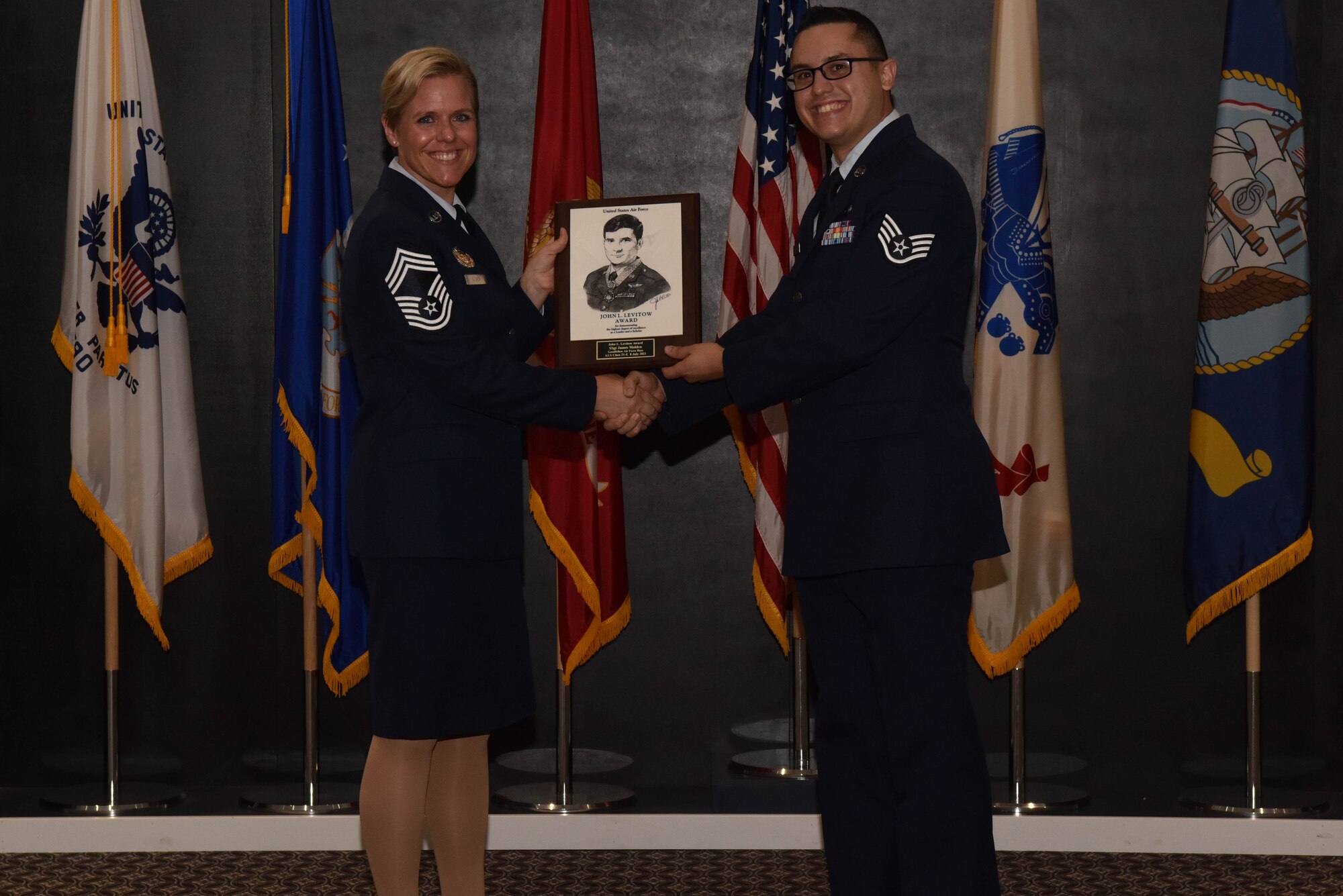 U.S. Air Force Chief Master Sgt. Breana Oliver, 17th Training Group superintendent, presents Staff Sgt. James Molden, 17th Contacting Squadron contract specialist, the John L. Levitow award during Molden’s Airman Leadership School graduation ceremony on Goodfellow Air Force Base, Texas, July 8, 2021. The John L. Levitow award is the highest award possible in professional military education and is based upon all performance tasks, peer stratifications and the capstone exercise. (U.S. Air Force photo by Senior Airman Jermaine Ayers)