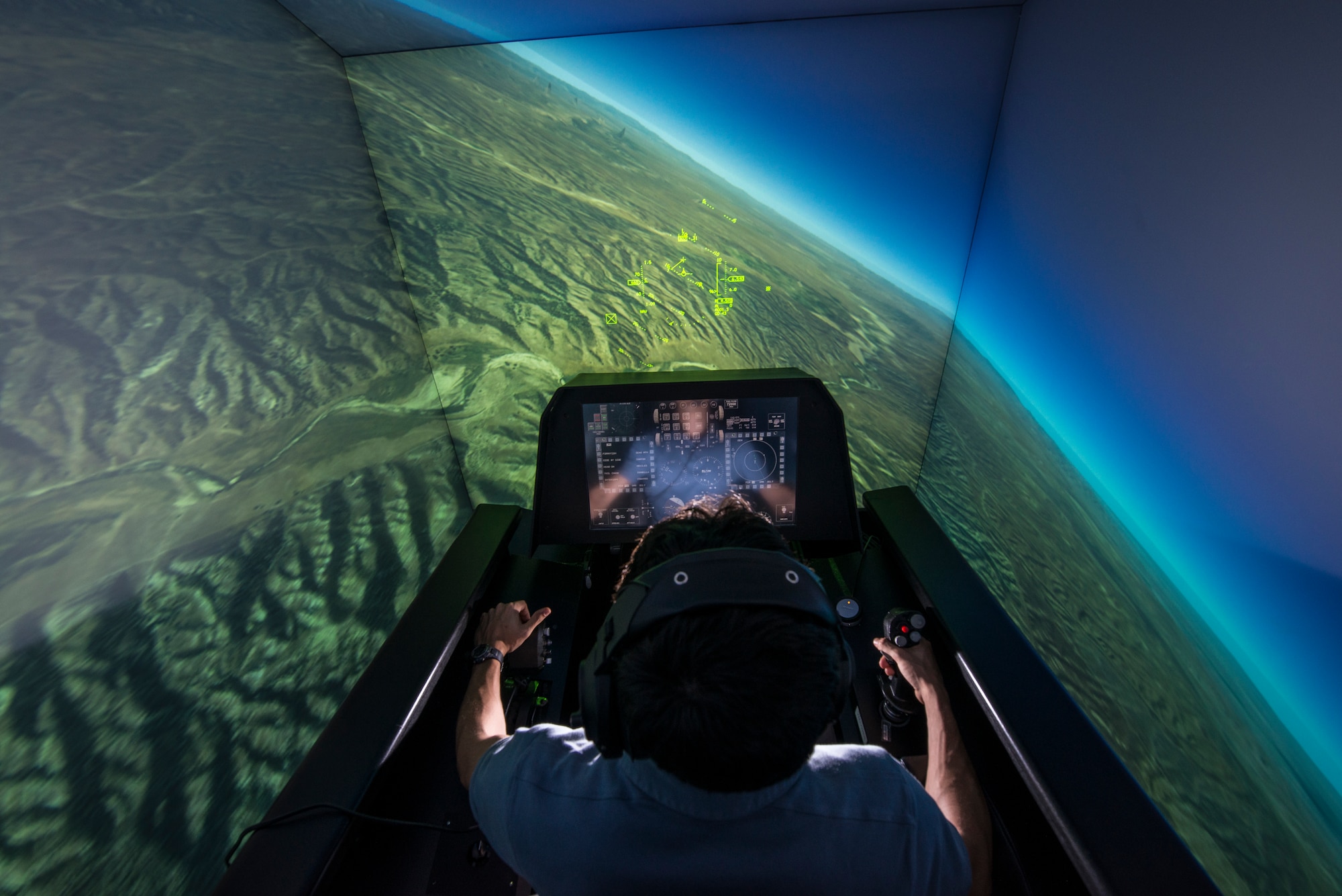 Zach Demers, an aerospace engineer, demonstrates the automatic ground collision avoidance system in an F-16 flight simulator at the Air Force Research Laboratory, Wright-Patterson Air Force Base, Ohio, April 18. Auto GCAS is designed to automatically pull a jet away from the ground if a pilot is disoriented or unable to do so. (U.S. Air Force photo/Master Sgt. Brian Ferguson)