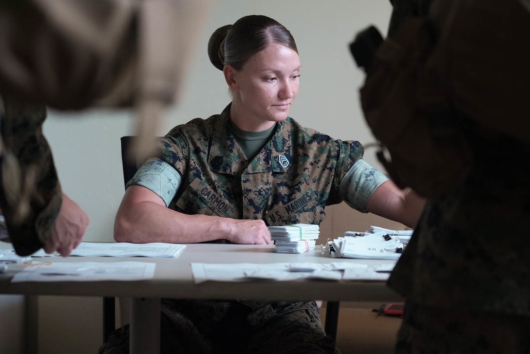 U.S. Marine Corps Gunnery Sgt. Brittany Carmon, a disbursing chief with Service Company, Combat Logistics Regiment 37, 3d Marine Logistics Group, disburses cash to Marines during an exercise on Camp Foster, Okinawa, Japan, June 18, 2021. The exercise simulates the financial exchanges for services acquired while in other nations around the world. 3d MLG, based out of Okinawa, Japan, is a forward deployed combat unit that serves as III MEF’s comprehensive logistics and combat service support backbone for operations throughout the Indo-Pacific area of responsibility. (U.S. Marine Corps photo by Cpl. Moises Rodriguez)