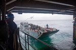 210630-N-IJ902-1139 Philippine Sea (June 30, 2021)—Sailors throw mooring lines to Landing Craft Utility 1633 (LCU 1633),  as it enters the well deck of amphibious dock landing ship, USS Germantown (LSD-42). Germantown, part of Amphibious Squadron 11, along with the 31st Marine Expeditionary Unit, is operating in the U.S. 7th Fleet area of responsibility to enhance interoperability with allies and partners and serve as a ready response force to defend peace and stability in the Indo-Pacific region. (U.S. Navy photo by Mass Communication Specialist Seaman Apprentice Nicholas M. Skyles)