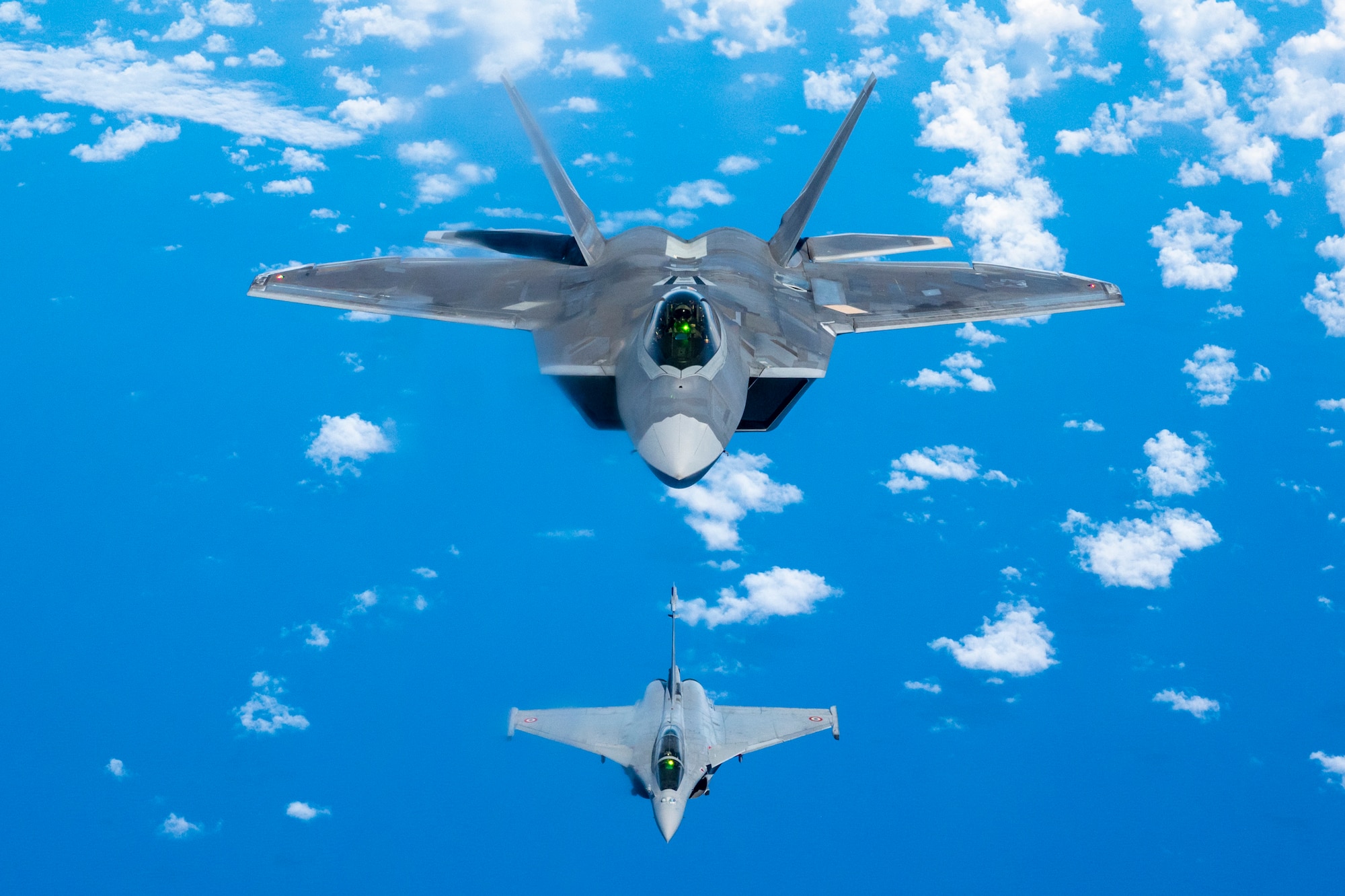 A Hawaii Air National Guard F-22 Raptor flies in formation with a French Air and Space Force F3-R Rafale June 30, 2021, near Oahu, Hawaii. FASF aircraft, maintenance, and support personnel traveled to Hawaii for exercise Wakea as part of the bilateral cooperation in the Pacific between the United States and France.
