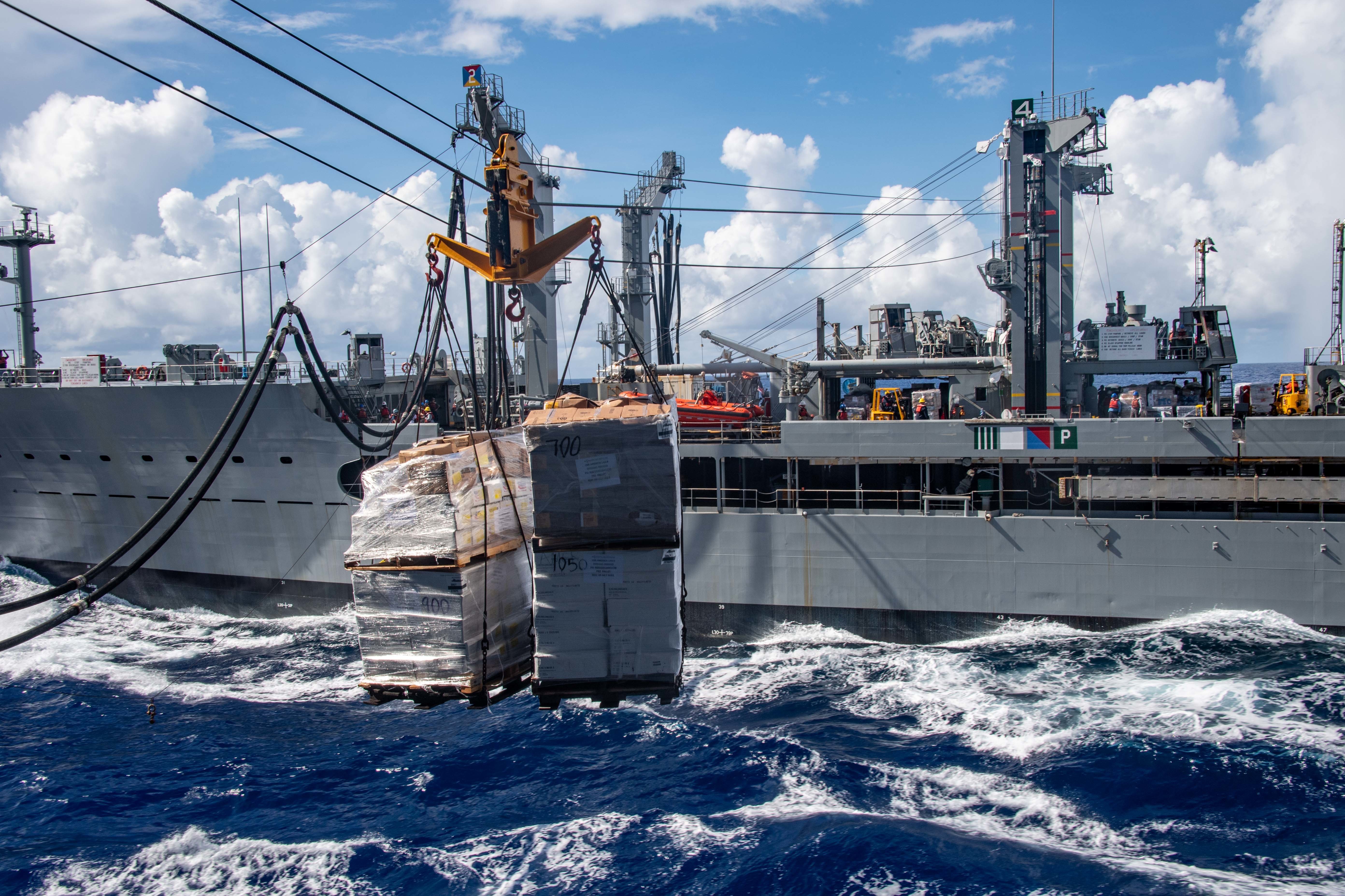 The forward-deployed amphibious assault ship USS America (LHA 6) conducts a replenishment-at-sea with the fleet replenishment oiler USNS Tippecanoe (T-AO 199).