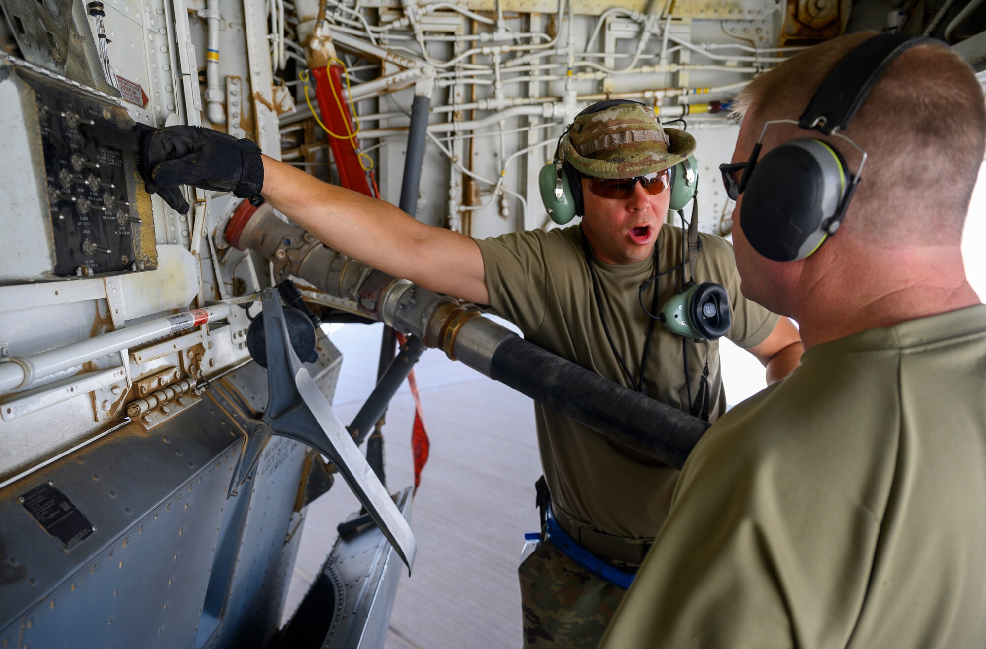 U.S. Air Force Tech. Sgt. Adam Barrett, 157th Expeditionary Fighter Generation Squadron dedicated crew chief, explains part of the hot pit refueling process on a U.S. Air Force KC-135 Stratotanker, Prince Sultan Air Base, June 25, 2021. This event demonstrated the success of several weeks of hot-pit refueling cross-airframe training between 378th and 379th Air Expeditionary Wing maintainers, expanding both wings ability to provide agile support for theater operations. (U.S. Air Force photo by Senior Airman Samuel Earick)