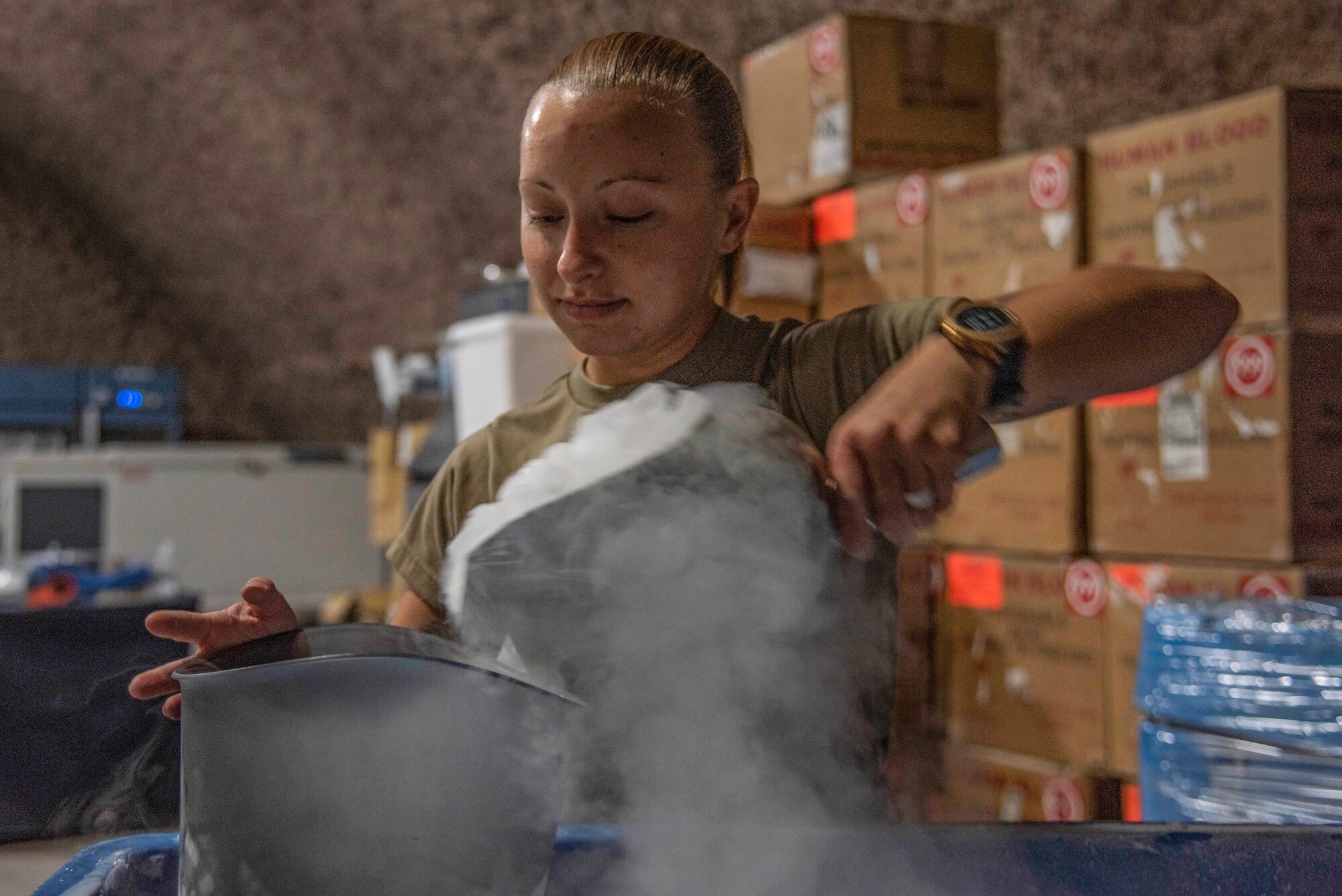 Staff Sgt. Rachel Rhoads, 379th Expeditionary Medical Support Squadron blood transshipment center NCO in charge, scoops dry ice into a bucket July 1, 2021, at Al Udeid Air Base, Qatar.