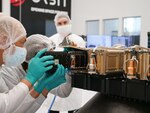Officials load a satellite.