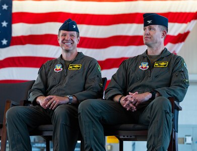 Airmen laugh during a change of command ceremony.