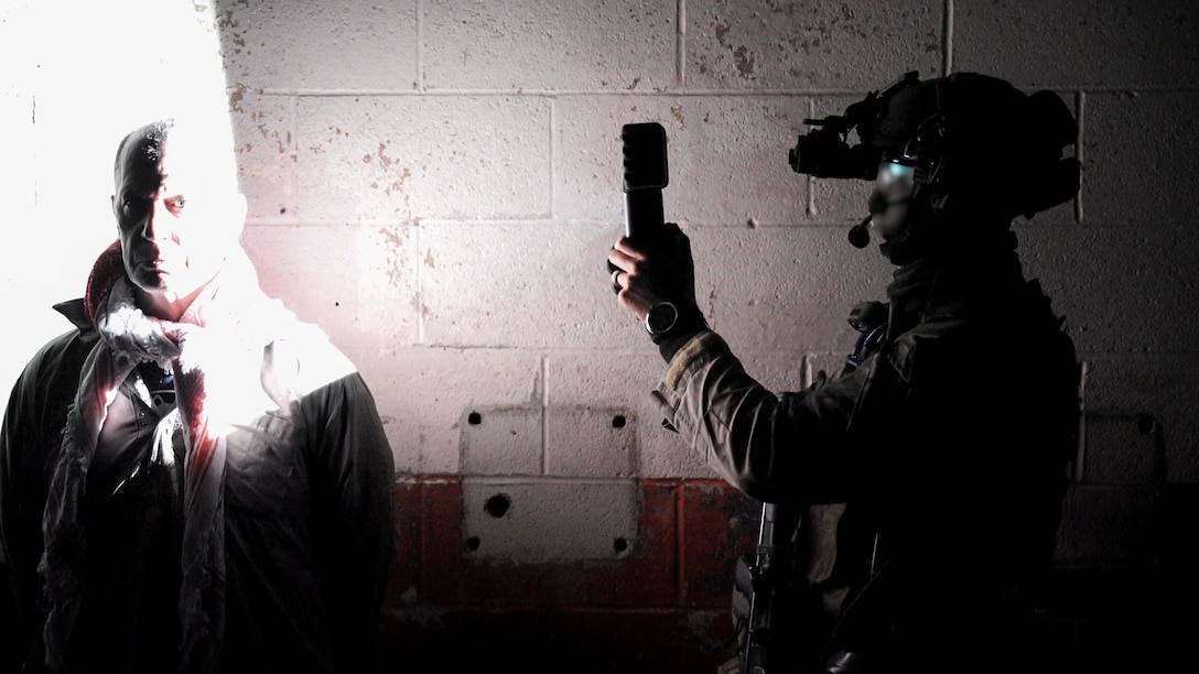 A Marine Raider photographs a simulated detainee during a RAVEN unit readiness exercise in Nashville, Tenn., May 11, 2021. RAVEN is a training exercise held to evaluate all aspects of a Marine Special Operations Company prior to a Marine Forces Special Operations Command deployment. (U.S. Marine Corps photo by Cpl. Brennan Priest)