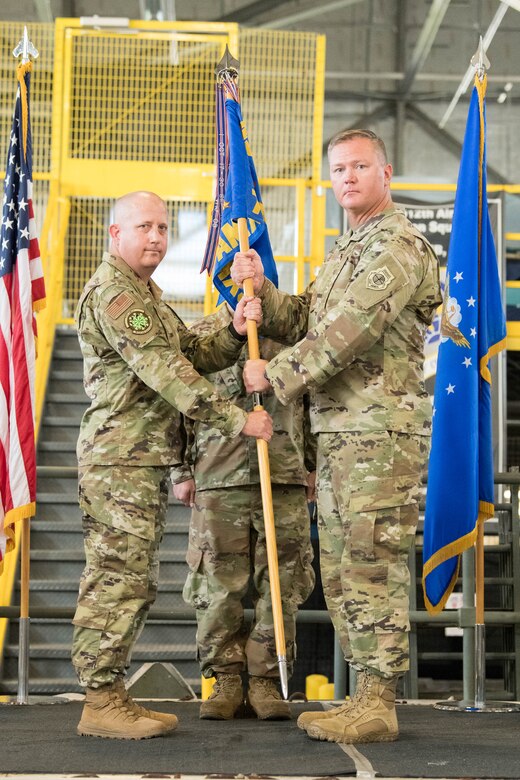 Lt. Col. Kevin Scholz, right, outgoing 736th Aircraft Maintenance Squadron commander, passes the guidon to Col. Bary Flack, 436th Maintenance Group commander, during a change of command ceremony at Dover Air Force Base, Delaware, July 9, 2021. The ceremony saw Scholz relinquish command to Maj. Shawn Cox. The squadron is responsible for the inspection, repair, launch and recovery of eight C-17 Globemaster III aircraft. (U.S. Air Force photo by Mauricio Campino)