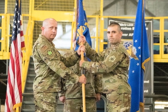 Col. Bary Flack, left, 436th Maintenance Group commander, passes the guidon to Maj. Shawn Cox, incoming 736th Aircraft Maintenance Squadron commander, during a change of command ceremony at Dover Air Force Base, Delaware, July 9, 2021. The ceremony saw Lt. Col. Kevin Scholz relinquish command to Cox. The squadron is responsible for the inspection, repair, launch and recovery of eight C-17 Globemaster III aircraft. (U.S. Air Force photo by Mauricio Campino)