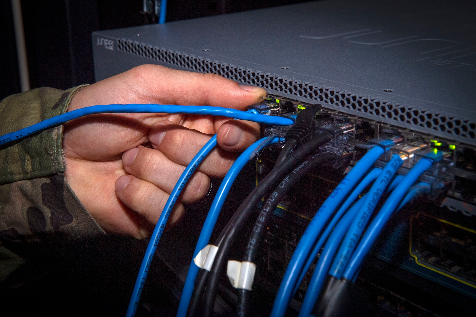 Tech. Sgt. Patrick Gildea, a 6th Communications Squadron (CS) Mission Defense Team supervisor, plugs in a new ethernet cable into a computer server at MacDill Air Force Base, Florida, July 8, 2021.
