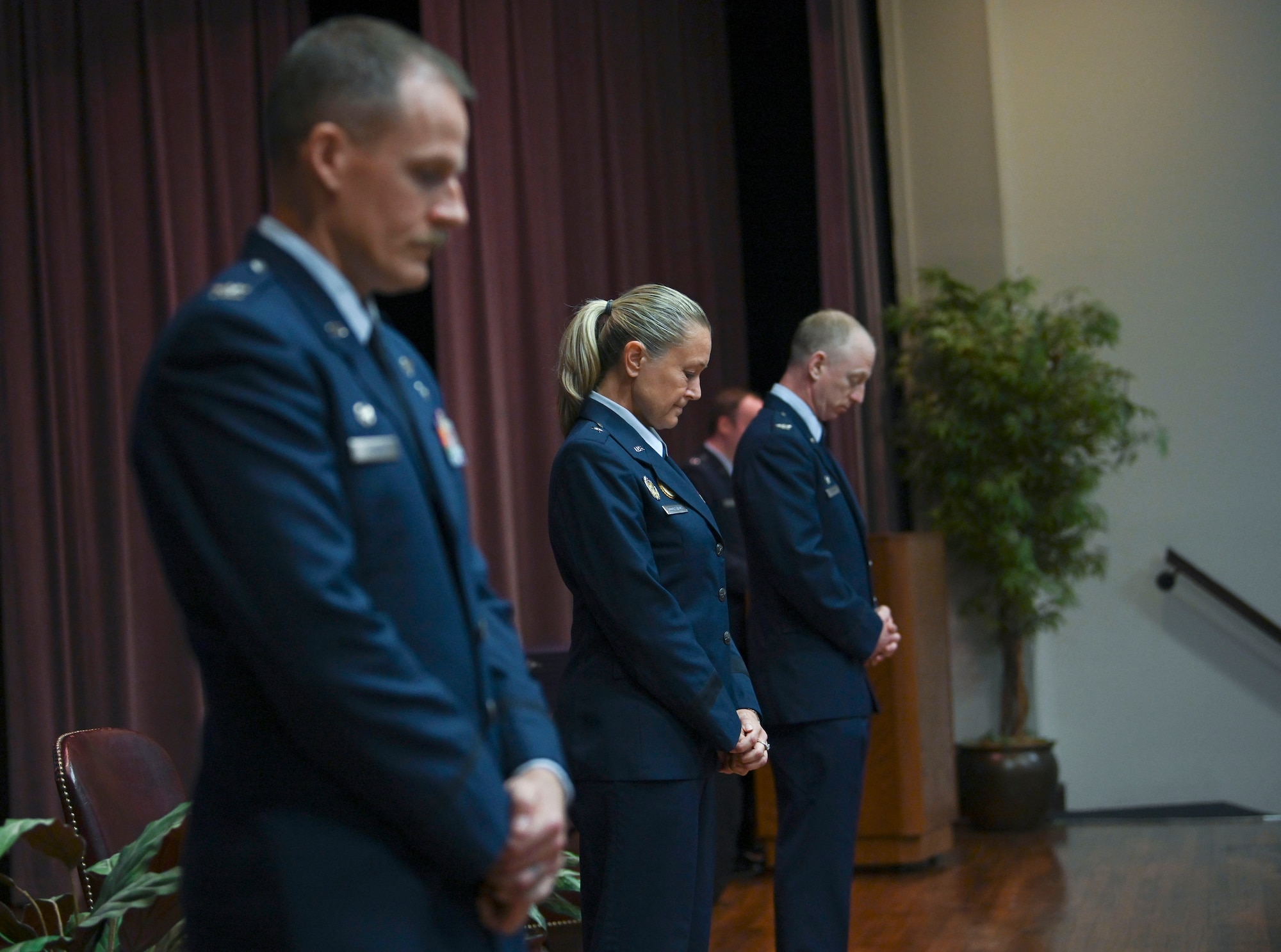 The official party attending the graduation of Specialized Undergraduate Pilot Training class 21-12 lower their heads in prayer July 9, 2021, on Columbus Air Force Base, Miss. The invocation was given by Chaplain (Capt.) Joshua Stevens after the National Anthem was played. (U.S. Air Force photo by Airman First Class Jessica Haynie)