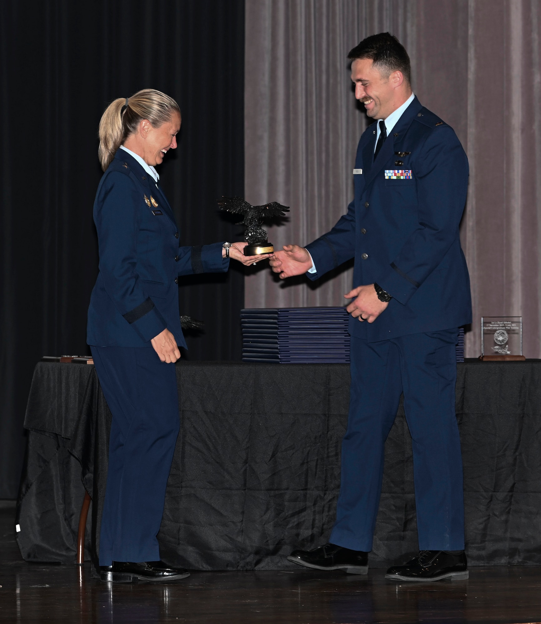 Brigadier General Bobbi Doorenbos (Retired) (Left) hands 2nd Lt. Jack Reis the Order of Daedalians Air Education & Training Command Commander’s Trophy July 9, 2021, on Columbus Air Force Base, Miss. The trophy is presented to the students who demonstrate outstanding performance with assigned check rides, daily flying operations, as well as maintains an exceptional commander's ranking and academic score. (U.S. Air Force photo by Airman First Class Jessica Haynie)