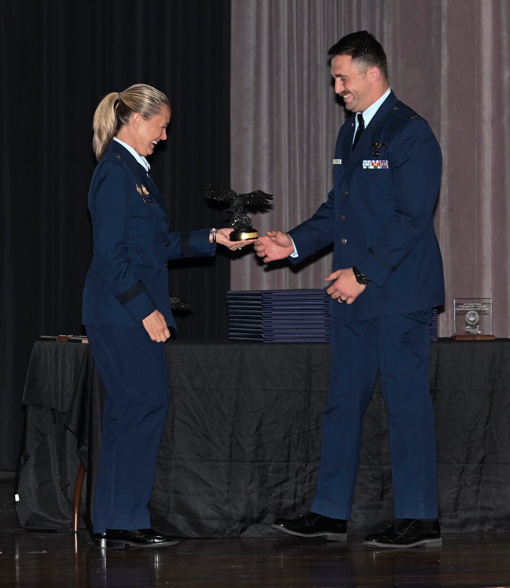 Brigadier General Bobbi Doorenbos (Retired) (Left) hands 2nd Lt. Jack Reis the Order of Daedalians Air Education & Training Command Commander’s Trophy July 9, 2021, on Columbus Air Force Base, Miss. The trophy is presented to the students who demonstrate outstanding performance with assigned check rides, daily flying operations, as well as maintains an exceptional commander's ranking and academic score. (U.S. Air Force photo by Airman First Class Jessica Haynie)