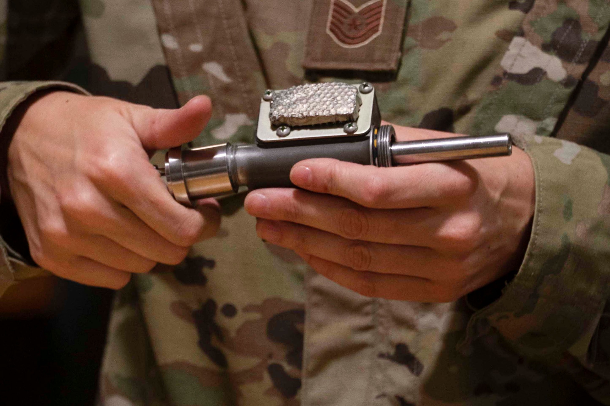 Photo of Airman holding a parachute firing mechanism