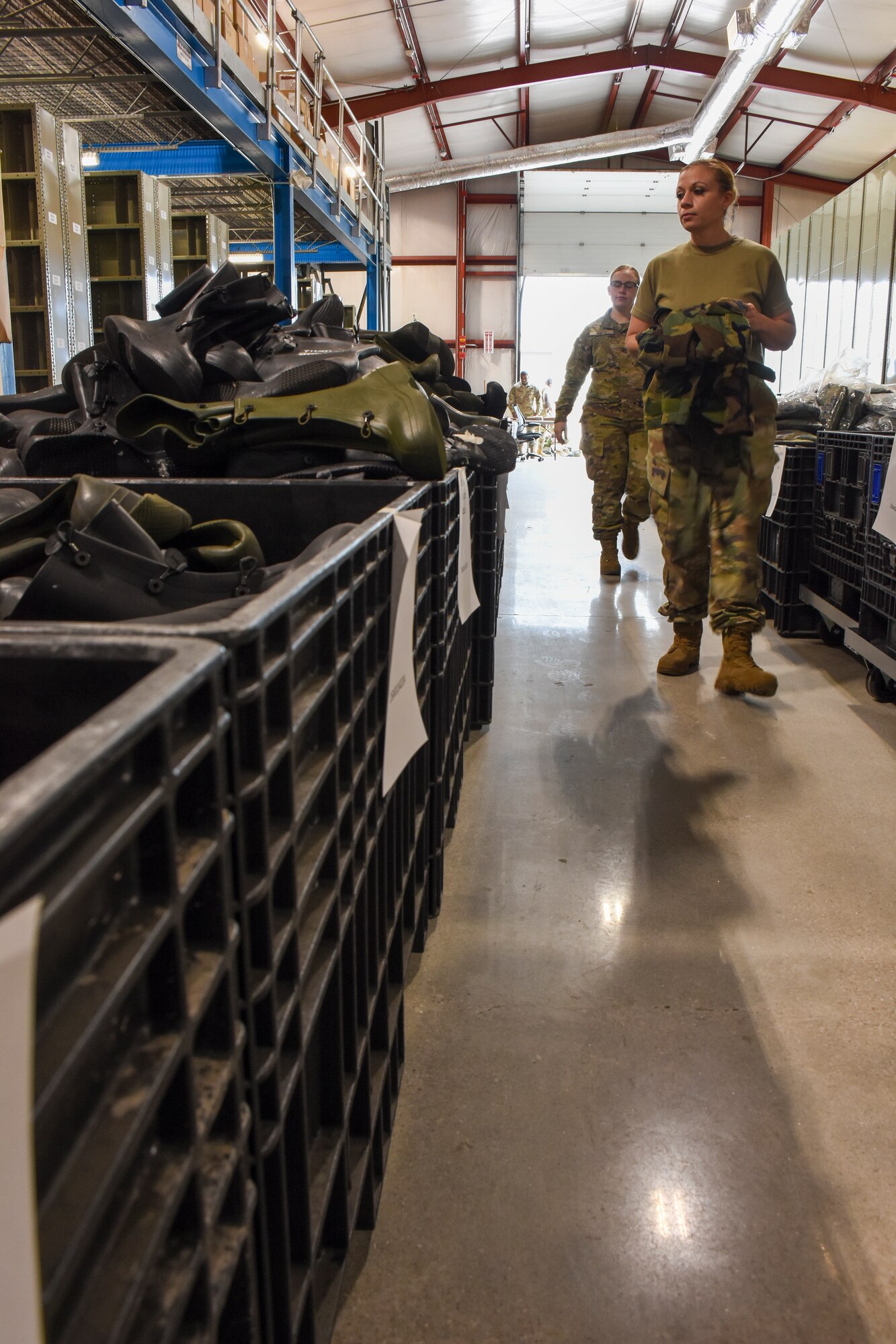 Master Sgt. Sara Montgomery, the 442d Logistics Readiness Squadron supply section NCOIC, carries a chemical protective overcoat to a bin