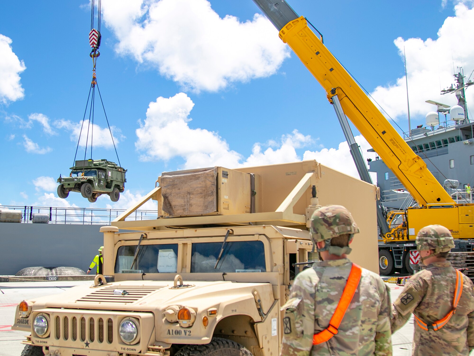 Soldiers from 593rd Expeditionary Sustainment Command observe a HMMWV being lifted from an Army Watercraft System in support of Forager 21, Naval Base Guam, July 10, 2021. Army Watercraft Systems deliver sealift capabilities that increase the Theater Army’s freedom of action and ability to flow forces to and within the region (U.S. Army photo by Spc. Richard Carlisi, I Corps Public Affairs)