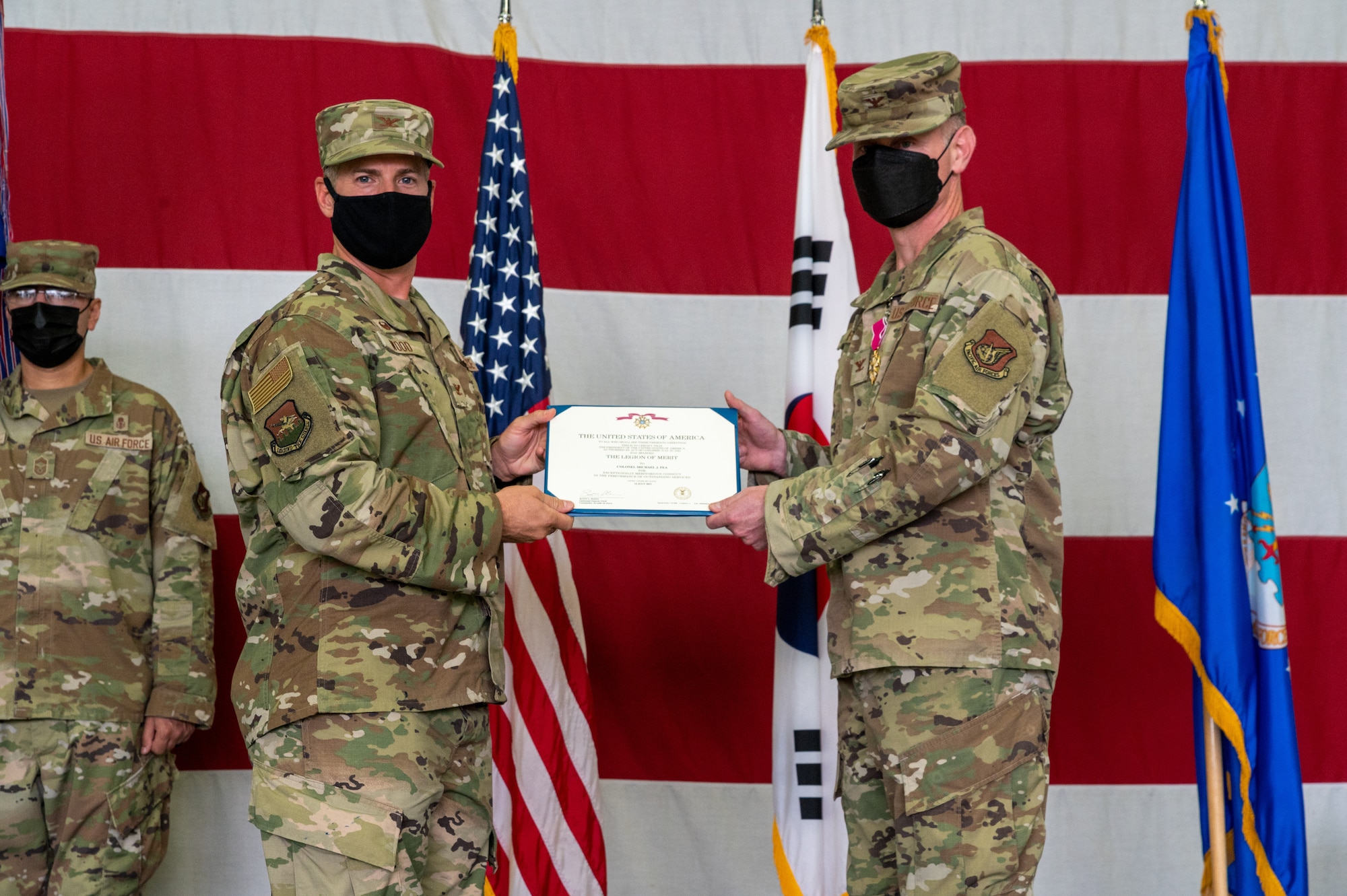 Col. Joshua Wood, 51st Fighter Wing commander, left, presents Col. Michael Fea, 51st Medical Group outgoing commander with a Legion of Merit decoration during the 51st Medical Group change of command ceremony at Osan Air Base, Republic of Korea, July 12, 2021. Fea earned the Legion of Merit for his meritorious conduct as the 51st Medical Group commander. (U.S. Air Force photo by Tech. Sgt. Nicholas Alder)
