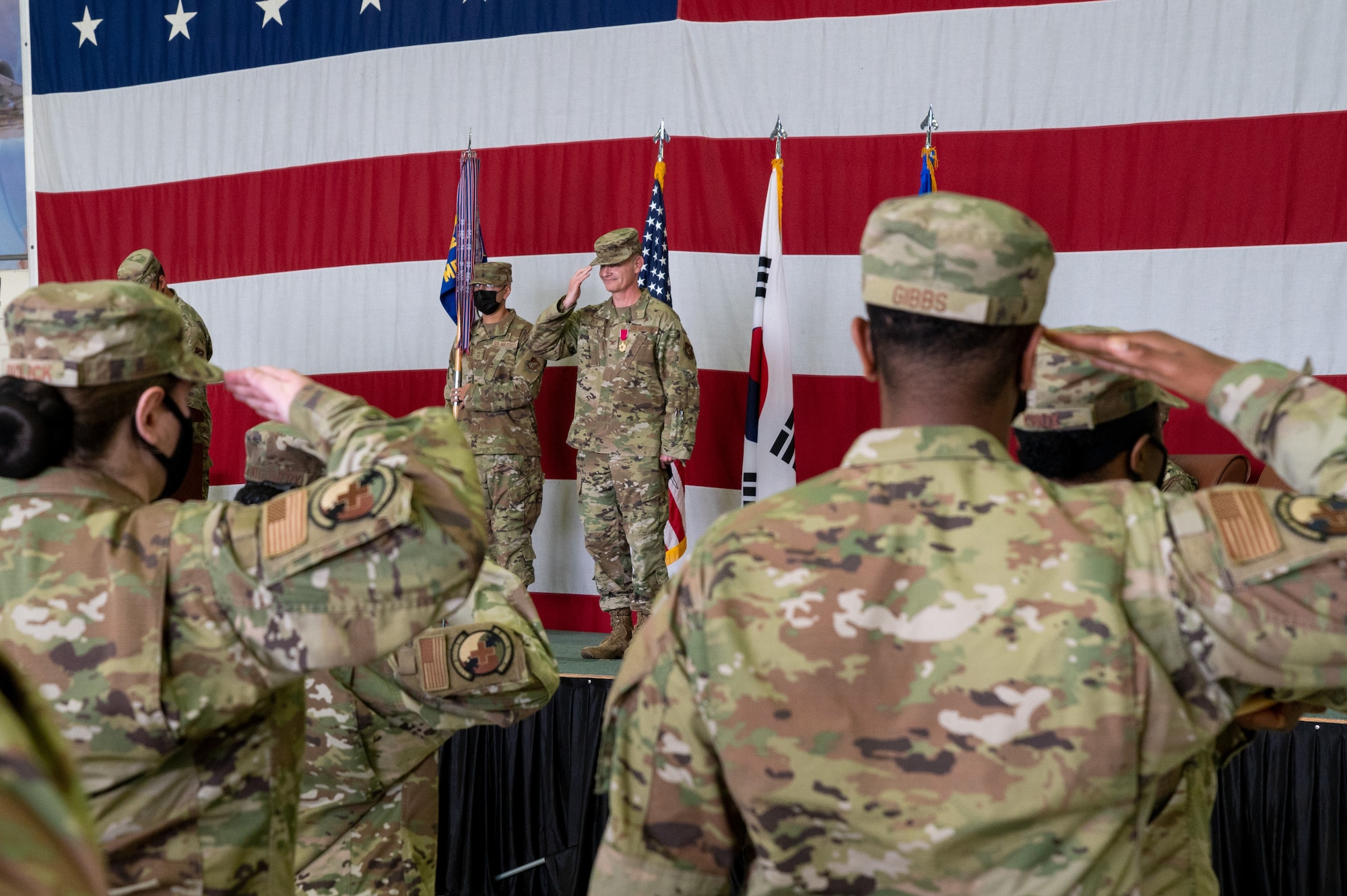 Col. Michael Fea, 51st Medical Group outgoing commander, returns a salute to his squadron during the change of command ceremony at Osan Air Base, Republic of Korea, July 12, 2021. The ceremonial passing of the guidon from Fea marks the official end of his command of the 51st MDG. (U.S. Air Force photo by Tech. Sgt. Nicholas Alder)