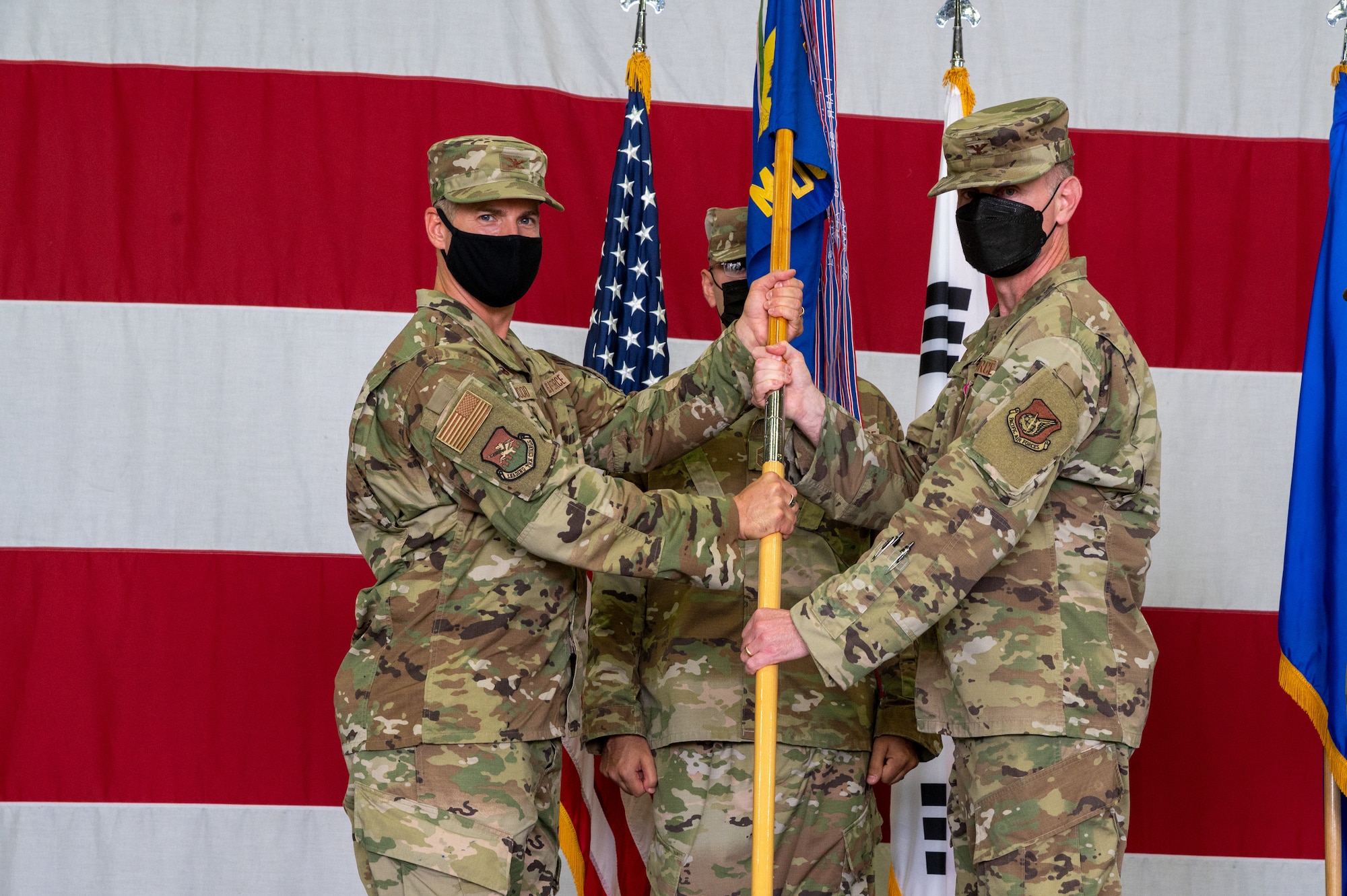 Col. Joshua Wood, 51st Fighter Wing commander, left, receives the 51st Medical Group guidon from Col. Michael Fea, 51st Medical Group outgoing commander, during the change of command ceremony at Osan Air Base, Republic of Korea, July 12, 2021. This act marks the official end of Fea’s command of the 51st MDG. (U.S. Air Force photo by Tech. Sgt. Nicholas Alder)