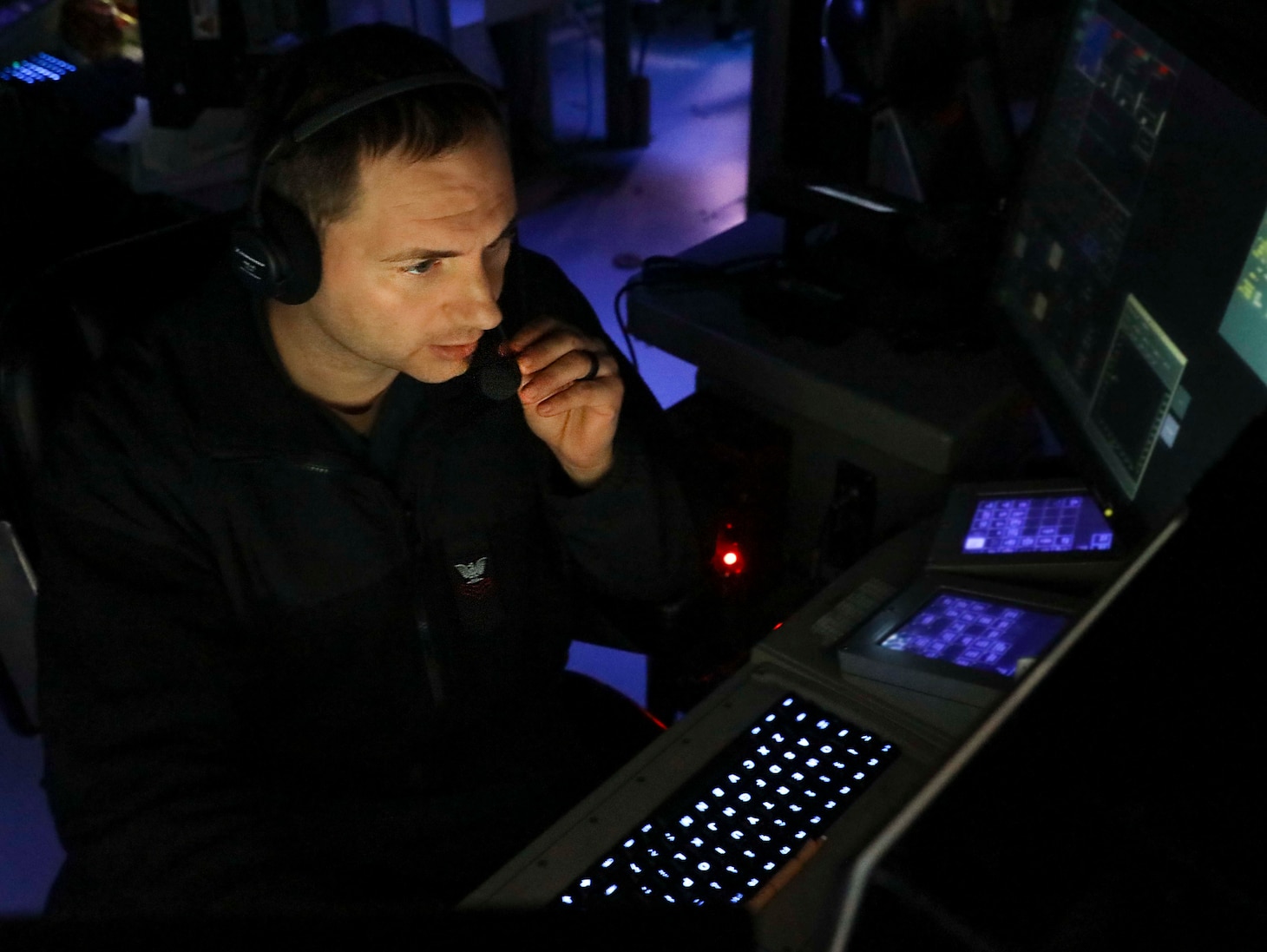 210712-N-FO714-2011 SOUTH CHINA SEA (July 12, 2021) Operations Specialist 1st Class Justin Brown, from Albany, N.Y., monitors the surface and air picture from inside the combat information center aboard Arleigh Burke-class guided-missile destroyer USS Benfold (DDG 65) while conducting routine underway operations. Benfold is forward-deployed to the U.S. 7th Fleet area of operations in support of a free and open Indo-Pacific. (U.S. Navy photo by Mass Communication Specialist 1st Class Deanna C. Gonzales)