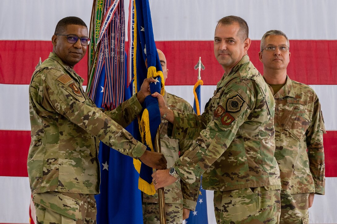 Two officers holding a guidon.