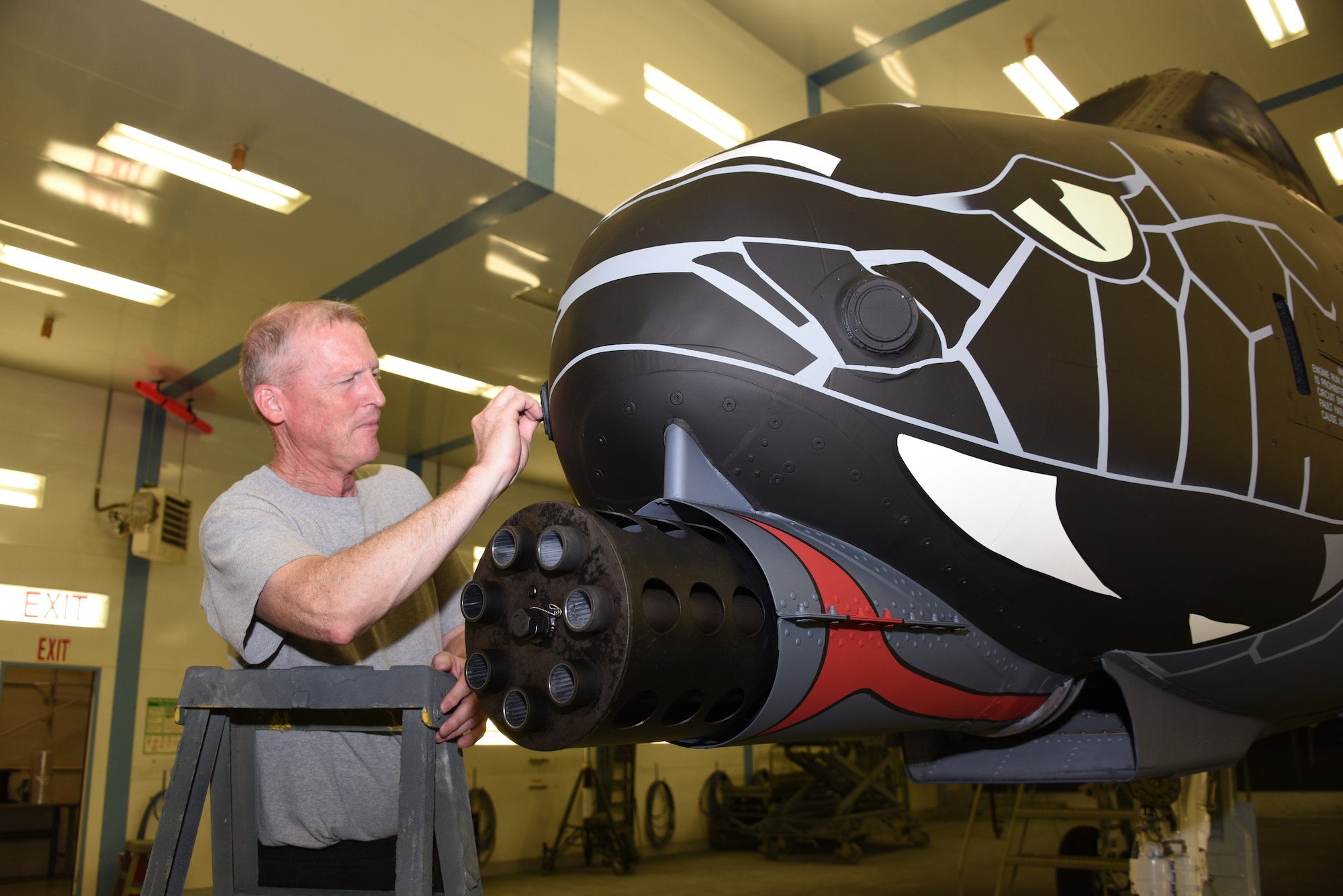 Technician Paul Grigsby cleans up stenciling on the nose of a U.S. Air Force A-10 Thunderbolt II in the paint booth at the Sioux City, Iowa, Air National Guard Paint Facility June 29, 2021. The non-standard paint scheme on the aircraft from the 122nd Fighter Wing commemorates the 100th anniversary of aviation in the Indiana National Guard.