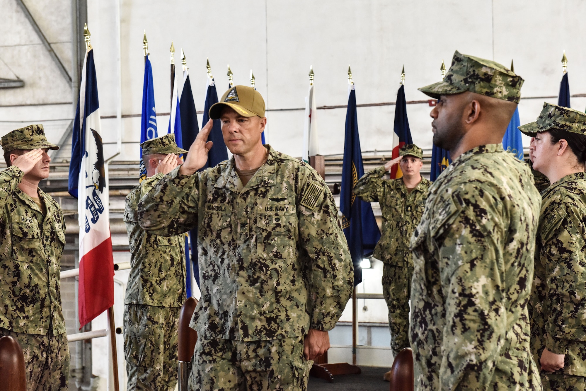 Incoming commander U.S. Navy Capt. Frank T. Ingargiola takes his place on stage during a change of command ceremony at Joint Base McGuire-Dix-Lakehurst, New Jersey, July 8, 2021.The ceremony took place atop an old flight deck inside historic Hangar 1. (U.S. Air Force Photo by Staff Sgt. Shay Stuart)