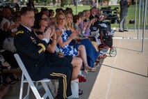 group of people in an audience applaud during a ceremony.